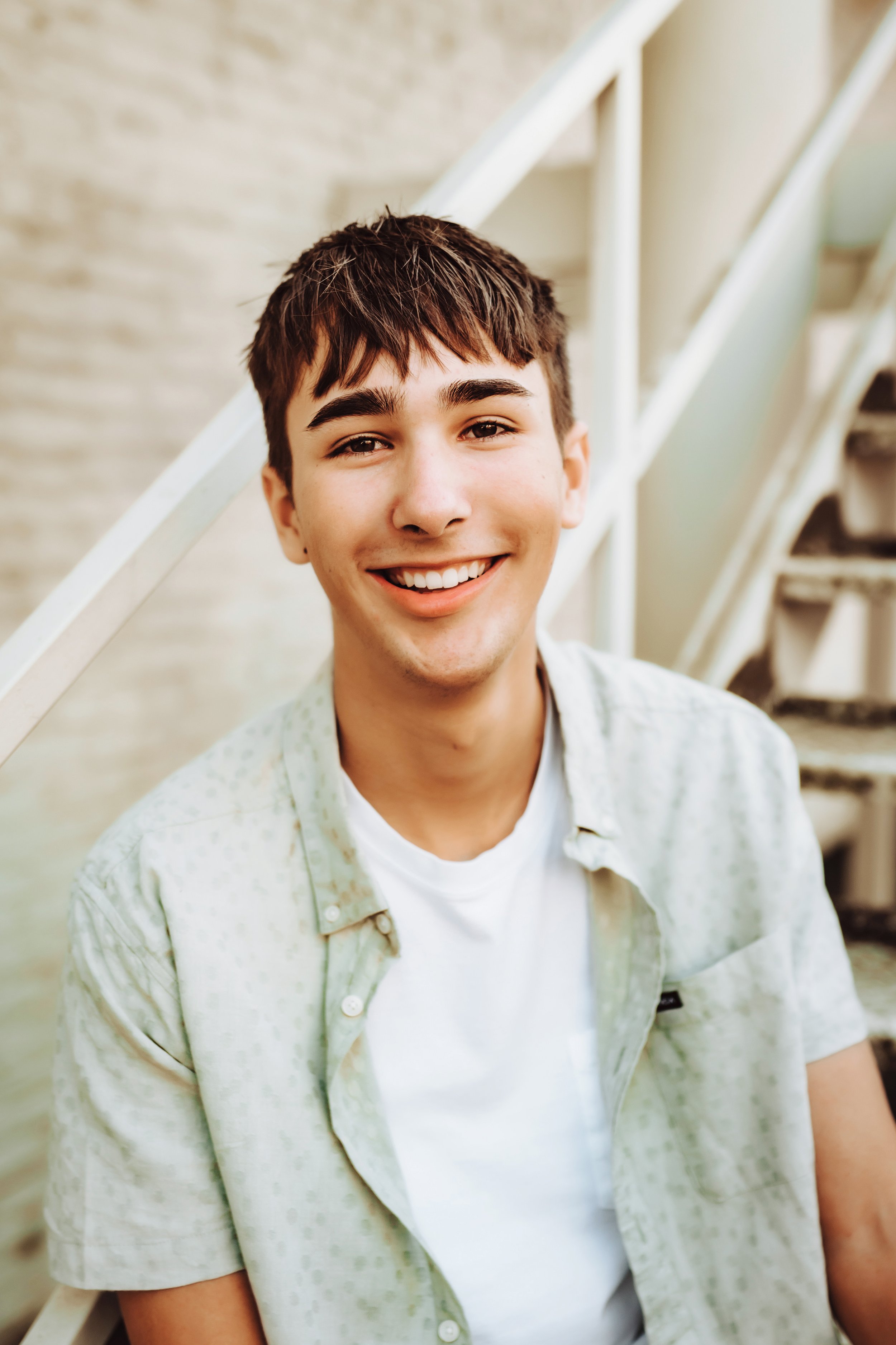 Senior boy sitting on stairs smiling