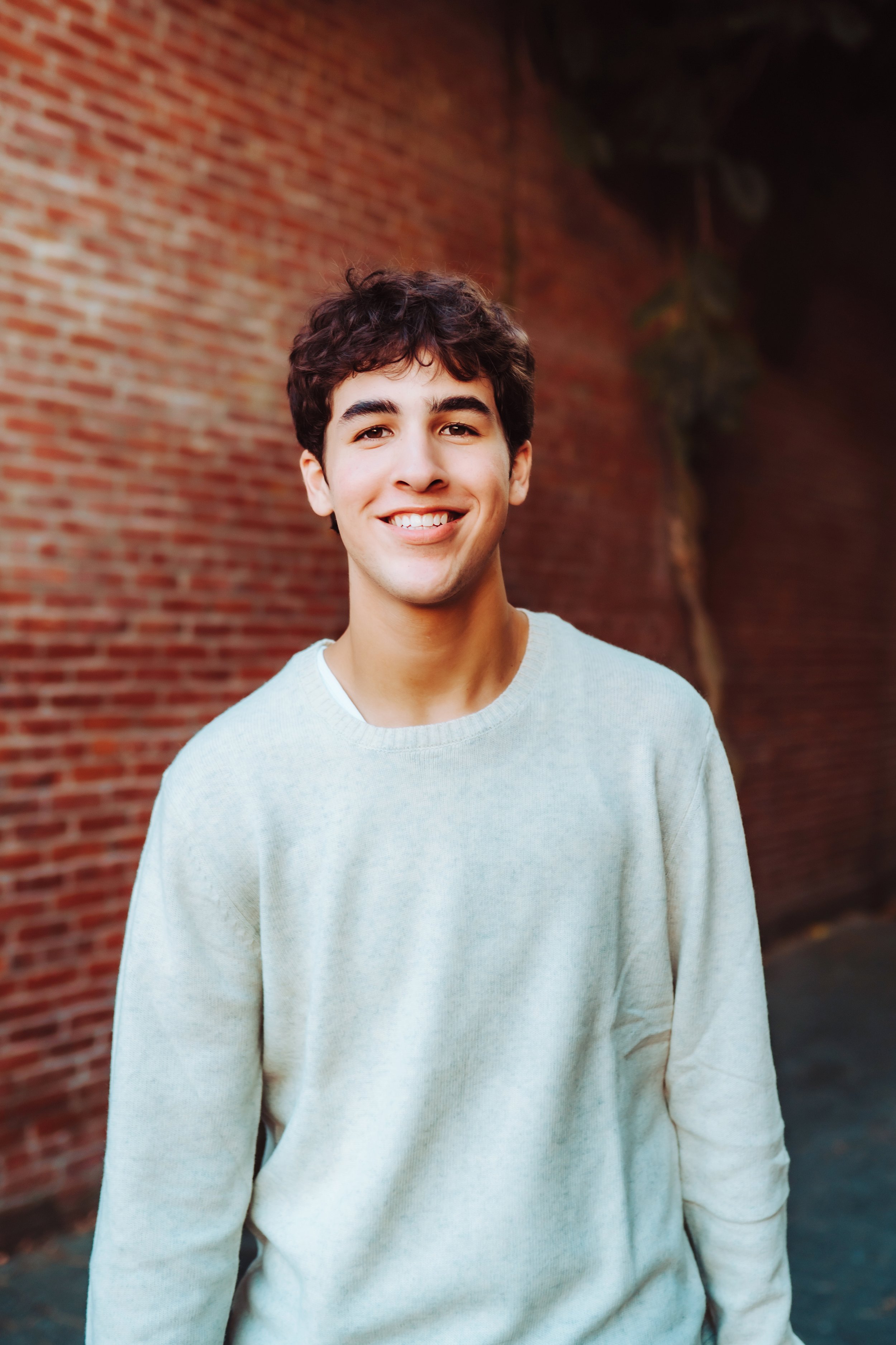 Senior boy against red brick wall