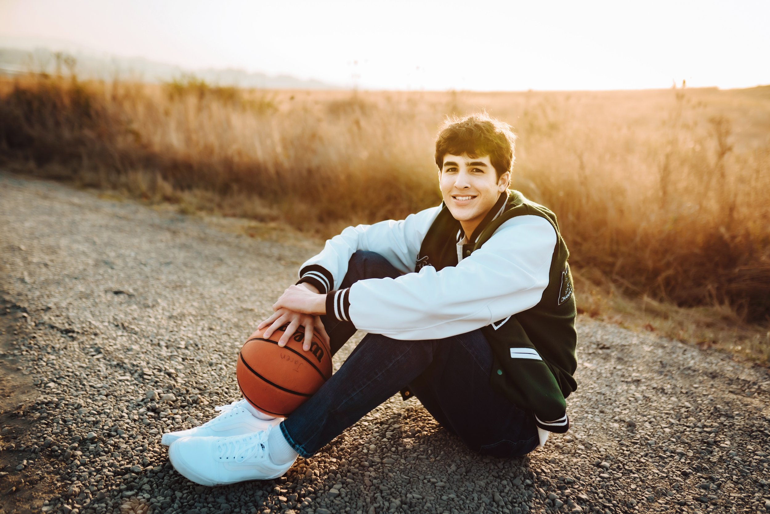 Senior boy sitting with basketball