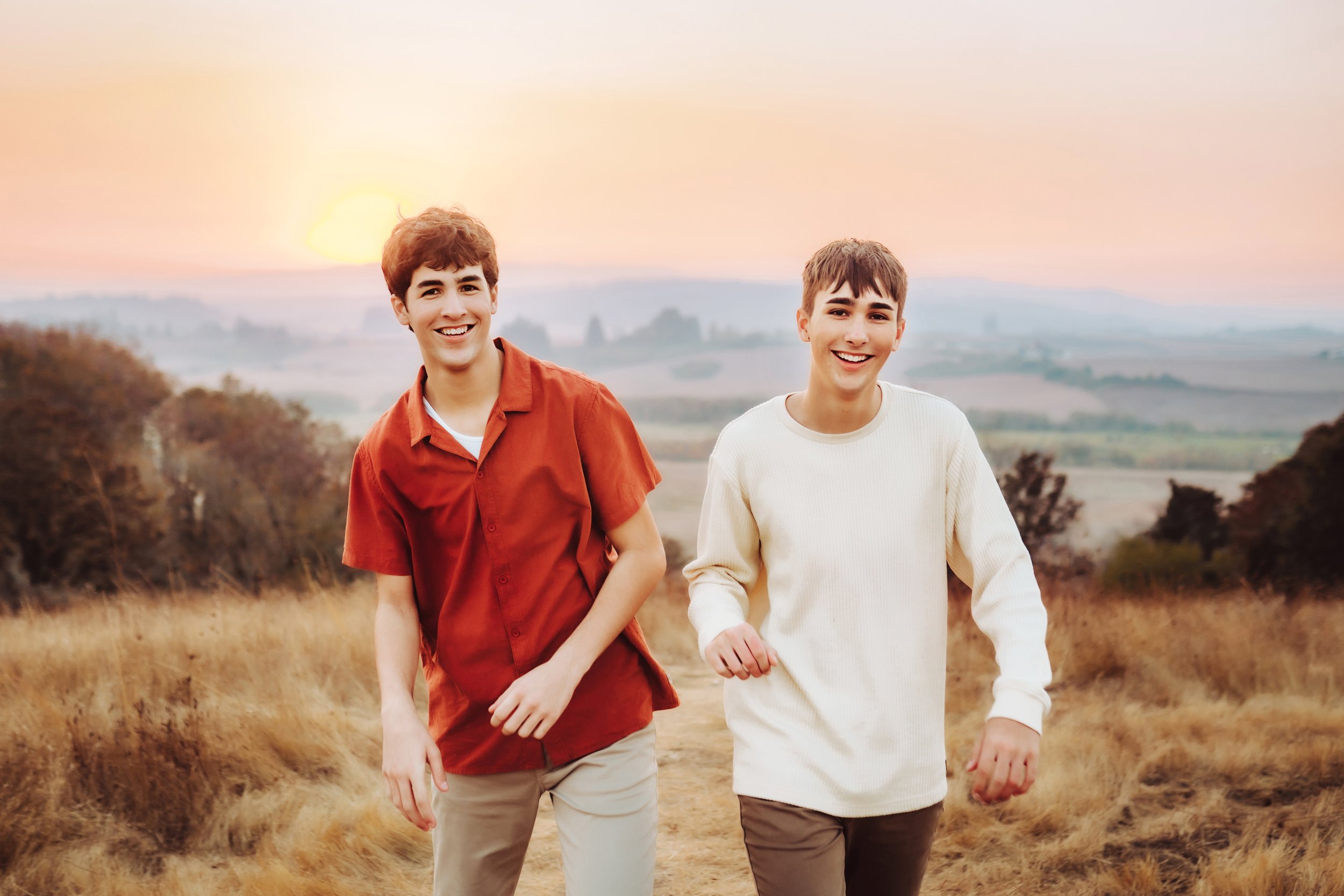 senior boys walking and laughing at sunset
