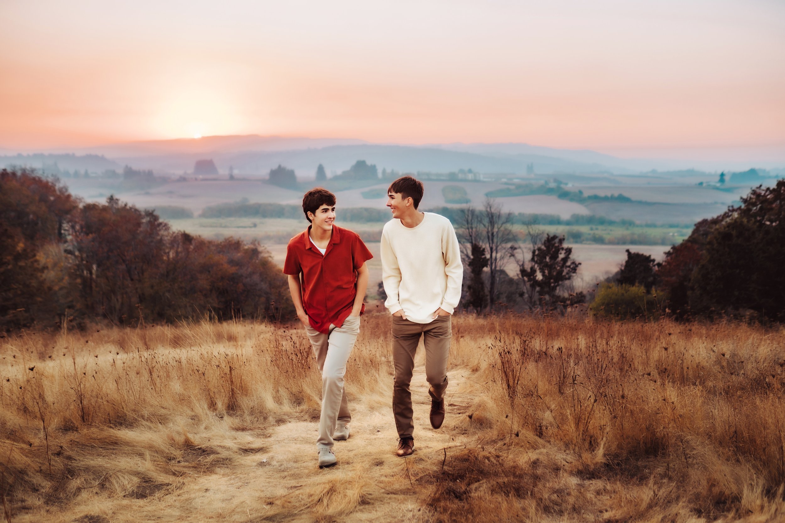 2 senior boys walking up path at sunset