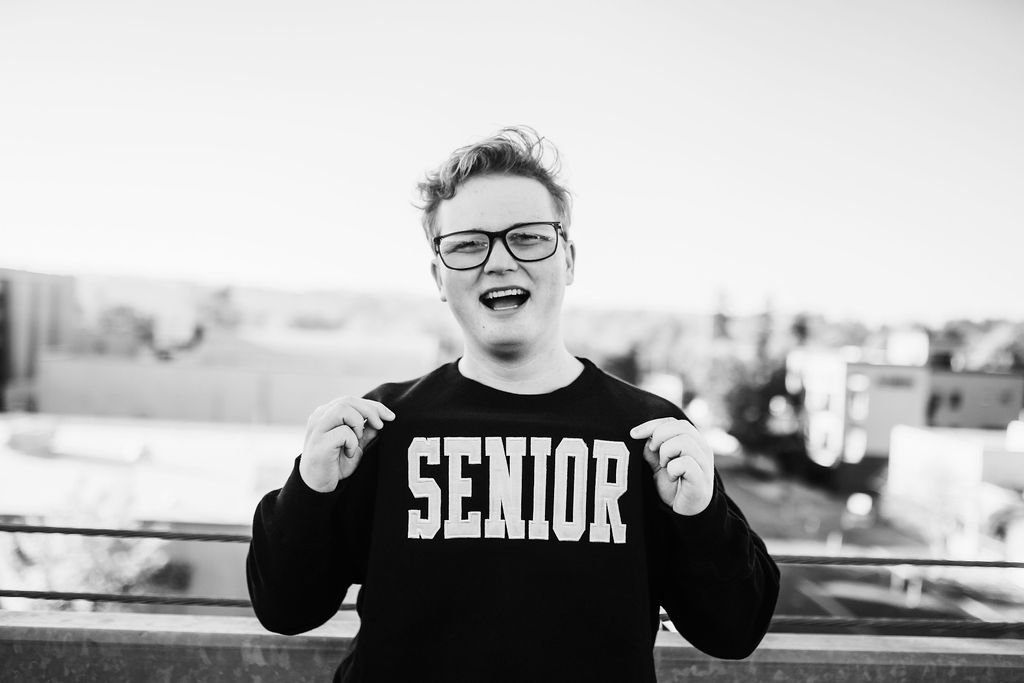 Max, holding up his senior sweatshirt for the camera