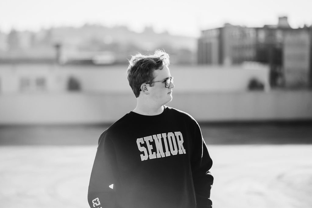 black and white senior picture of a senior staring off looking stoic