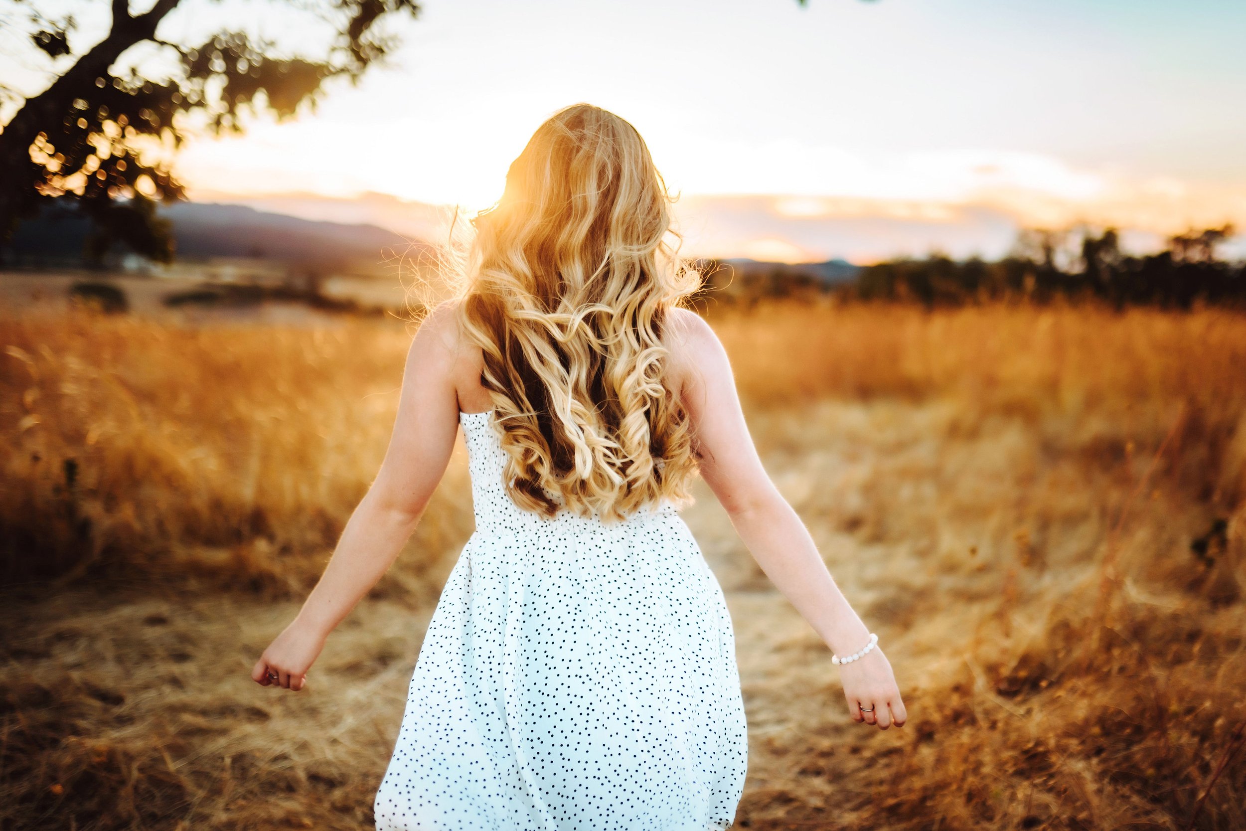 Senior girl walking into the sun