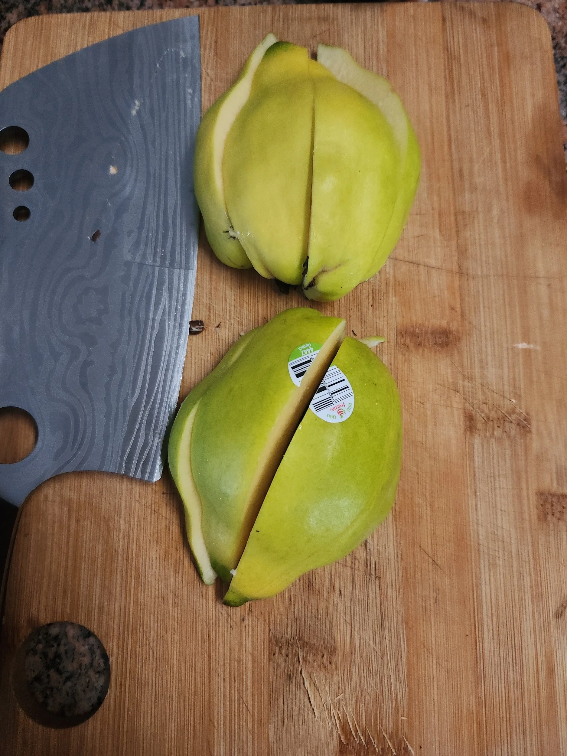 Quartered quince with knife on cutting board