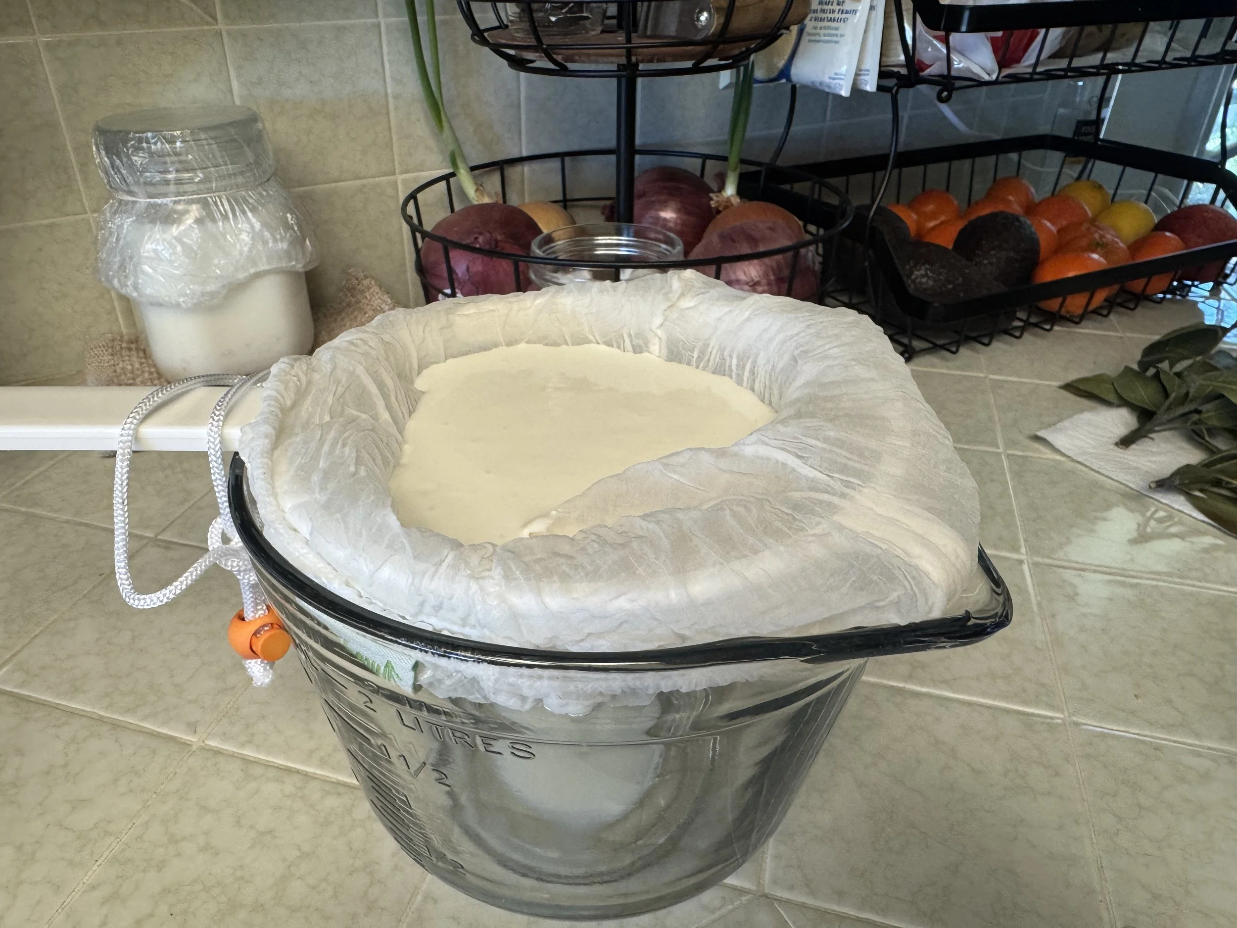 Milk kefir straining over a glass bowl