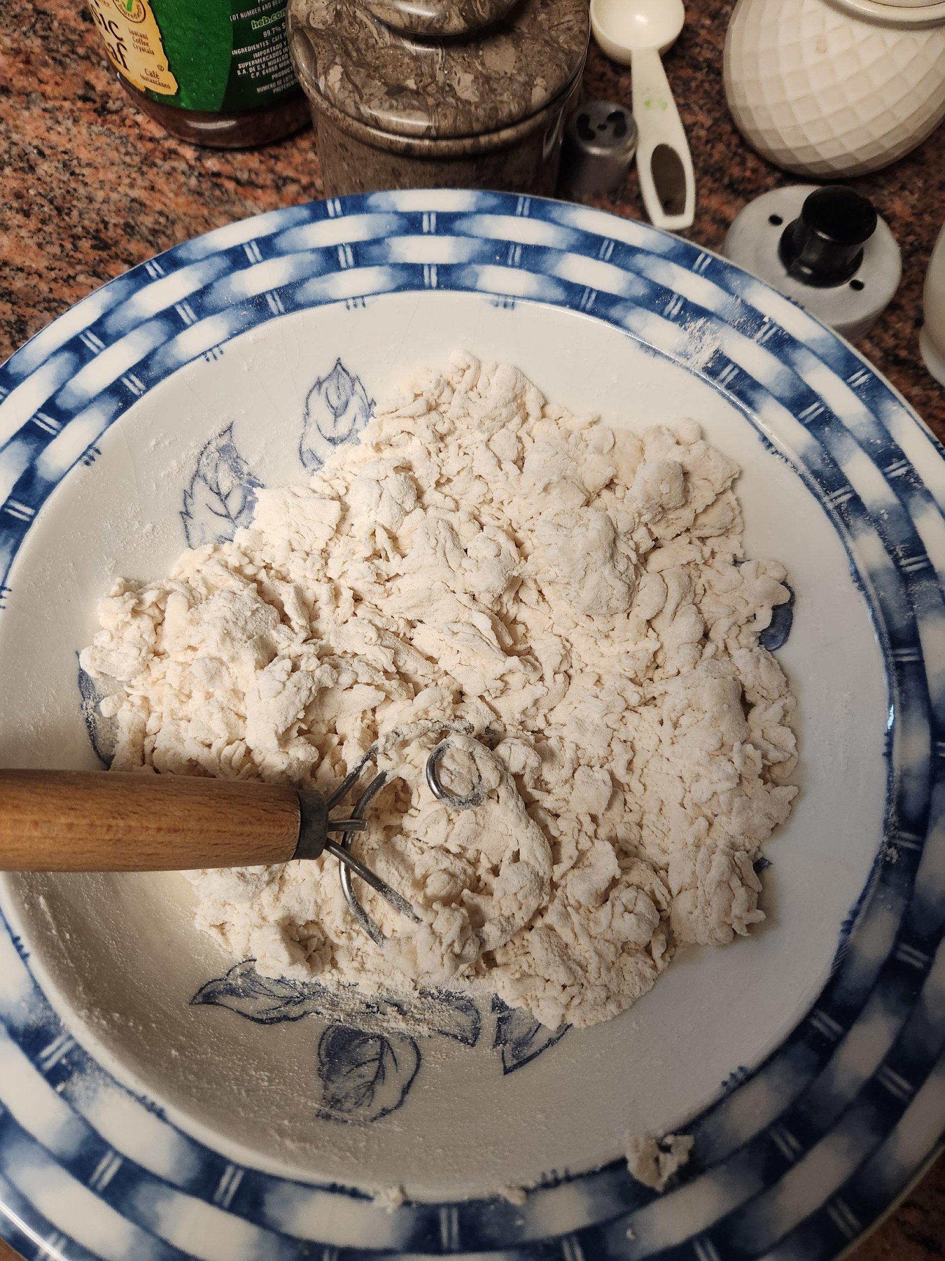 Bowl of dough being mixed with dough whisk