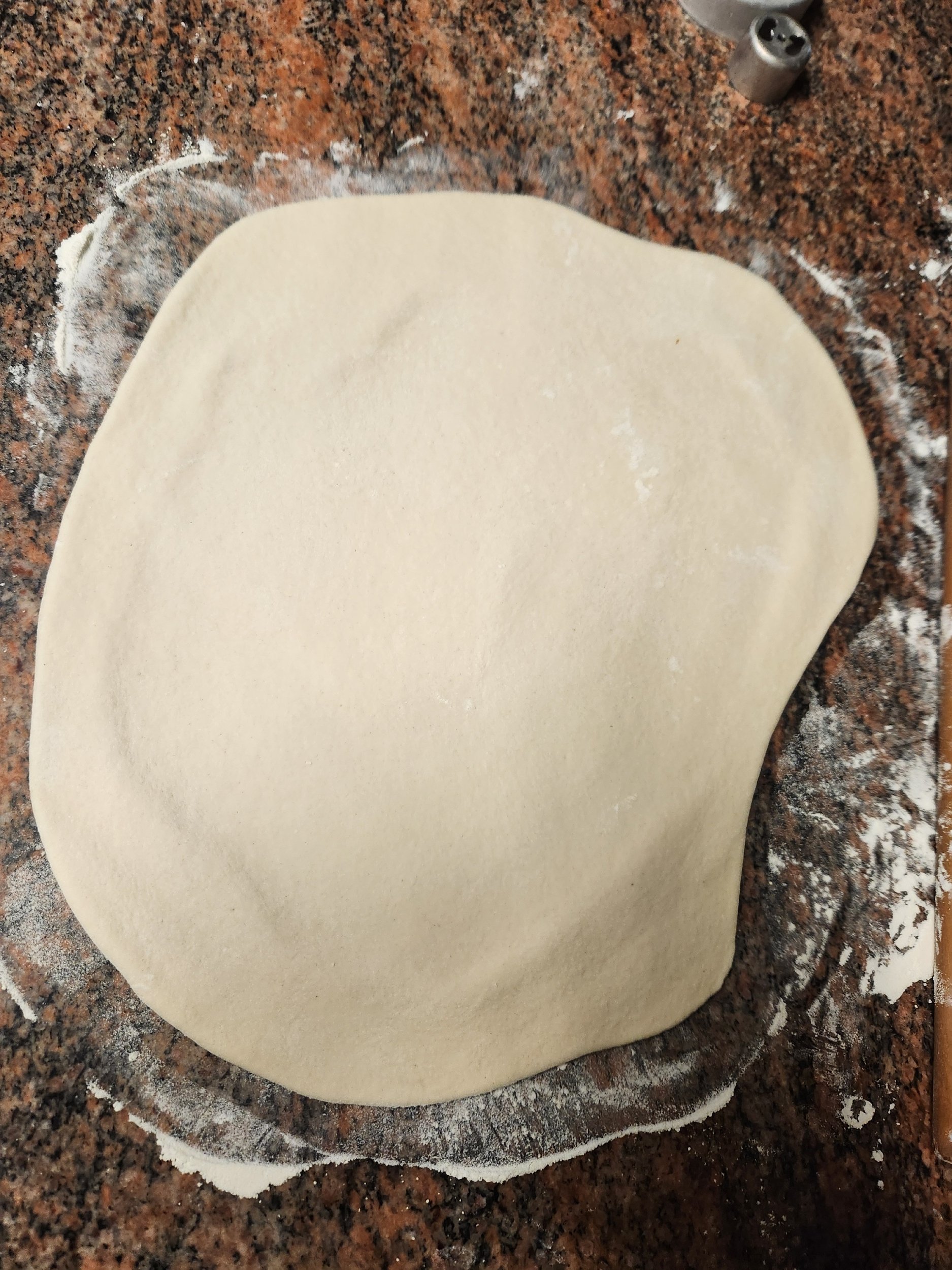 Dough being rolled out on floured counter