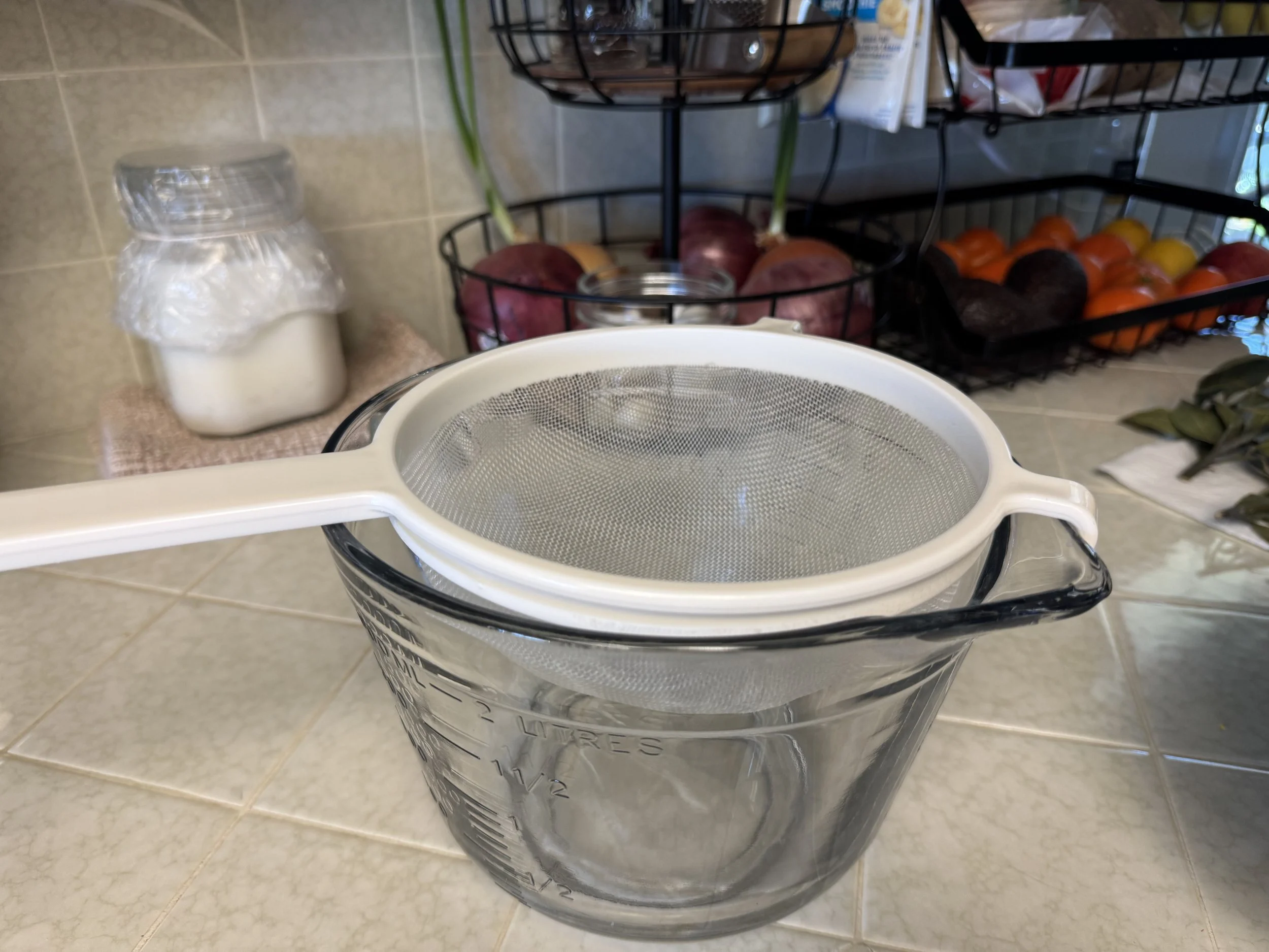 Mesh strainer over a glass bowl