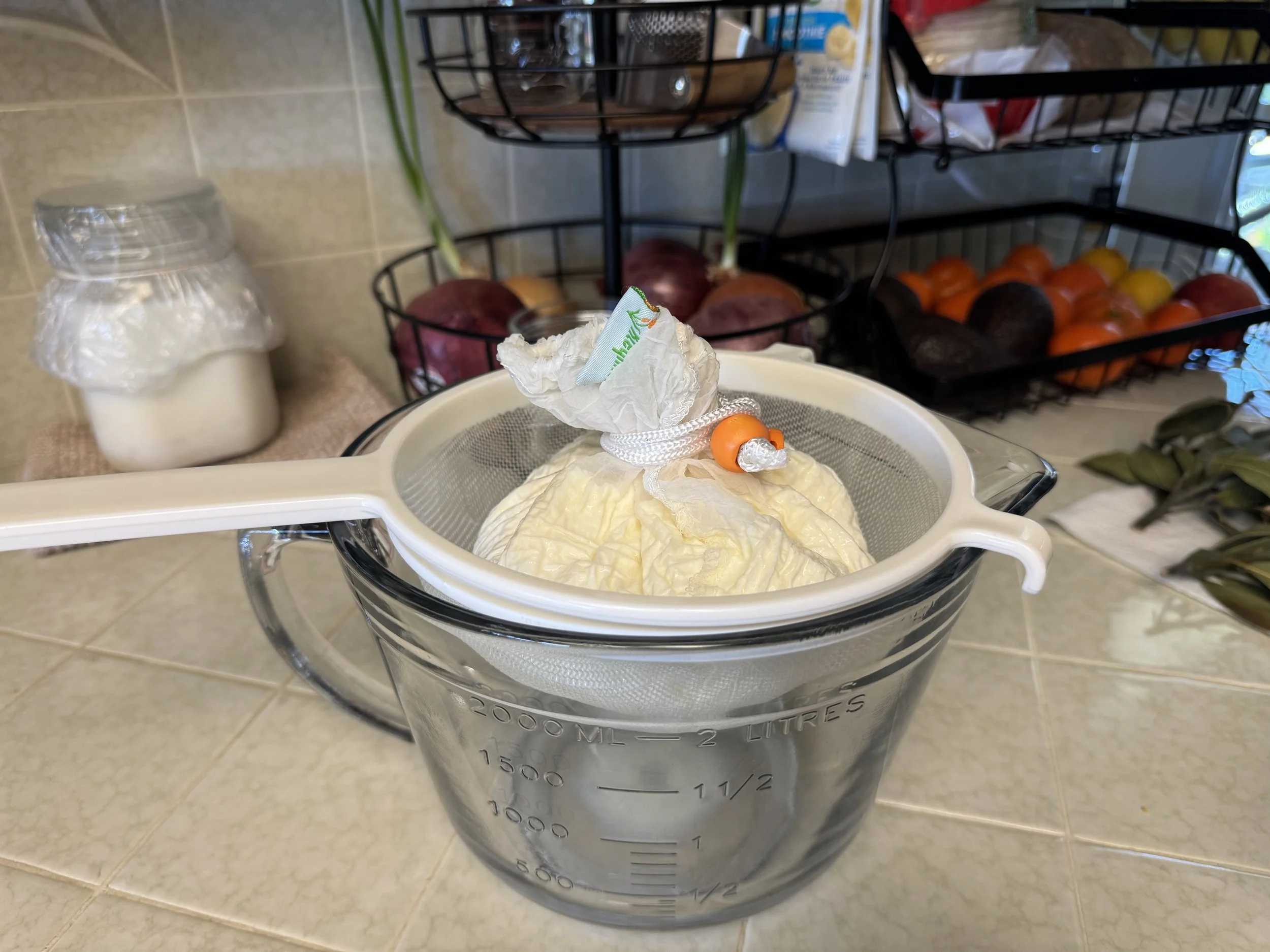 Milk kefir straining over a glass of bowl