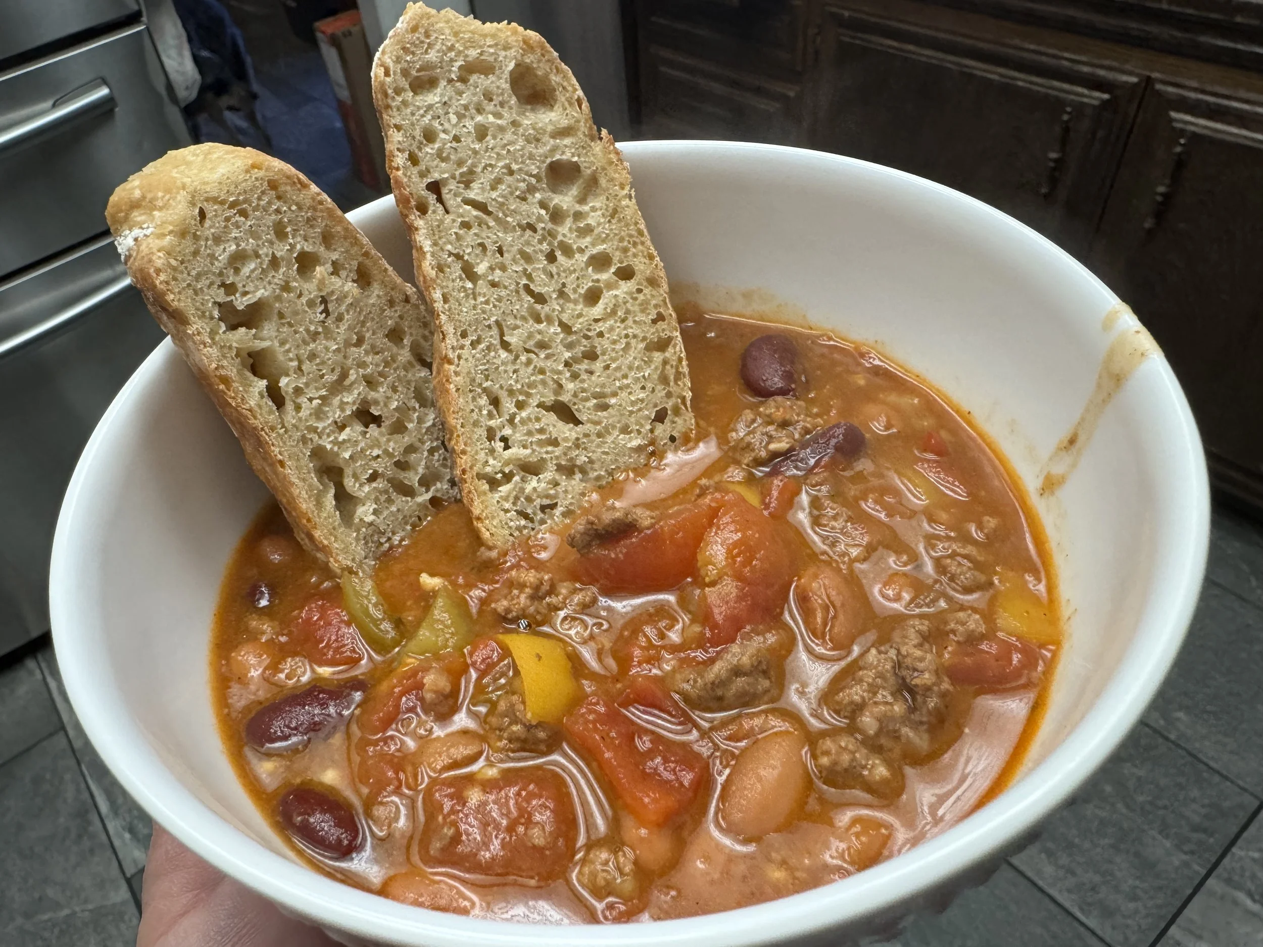 Bowl of chili beans with two slices of einkorn sourdough