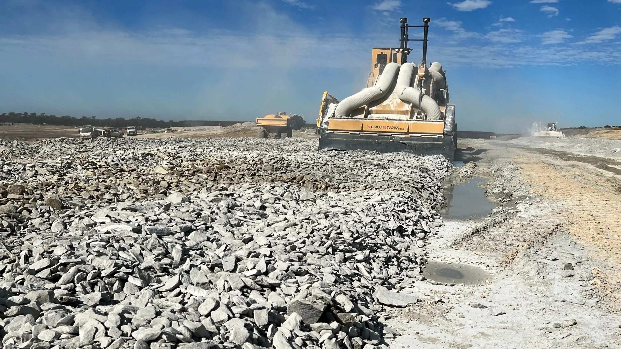 Trencor T16SM Surface Miner benching down sandstone to create a sound berm and road  between the M1 motorway and a adjacent subdivision at the Sunshine Coast in Queensland