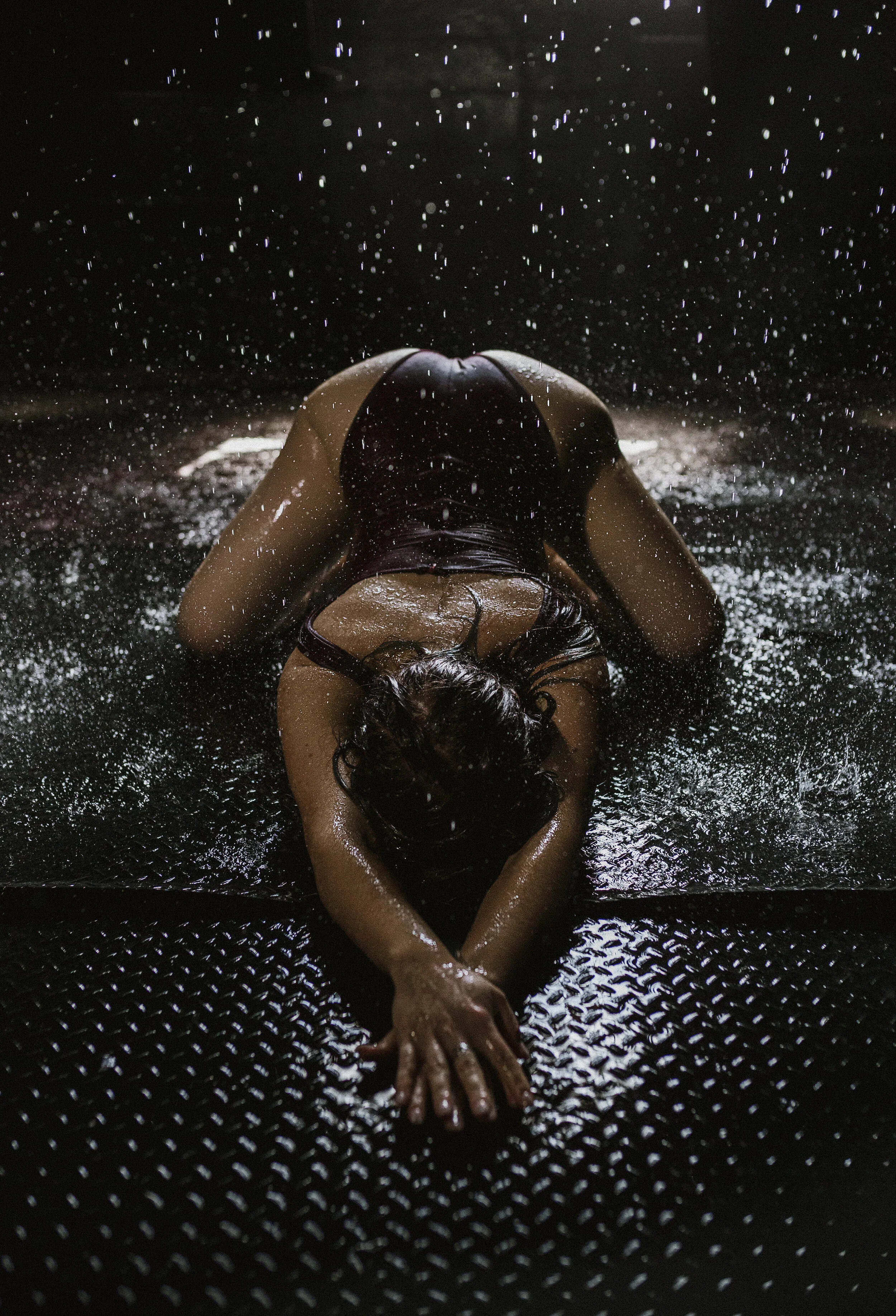 Southern California Boudoir Photography Of A Woman Laying Down Arching While Water Is Coming Down On Her Using Natural Light
