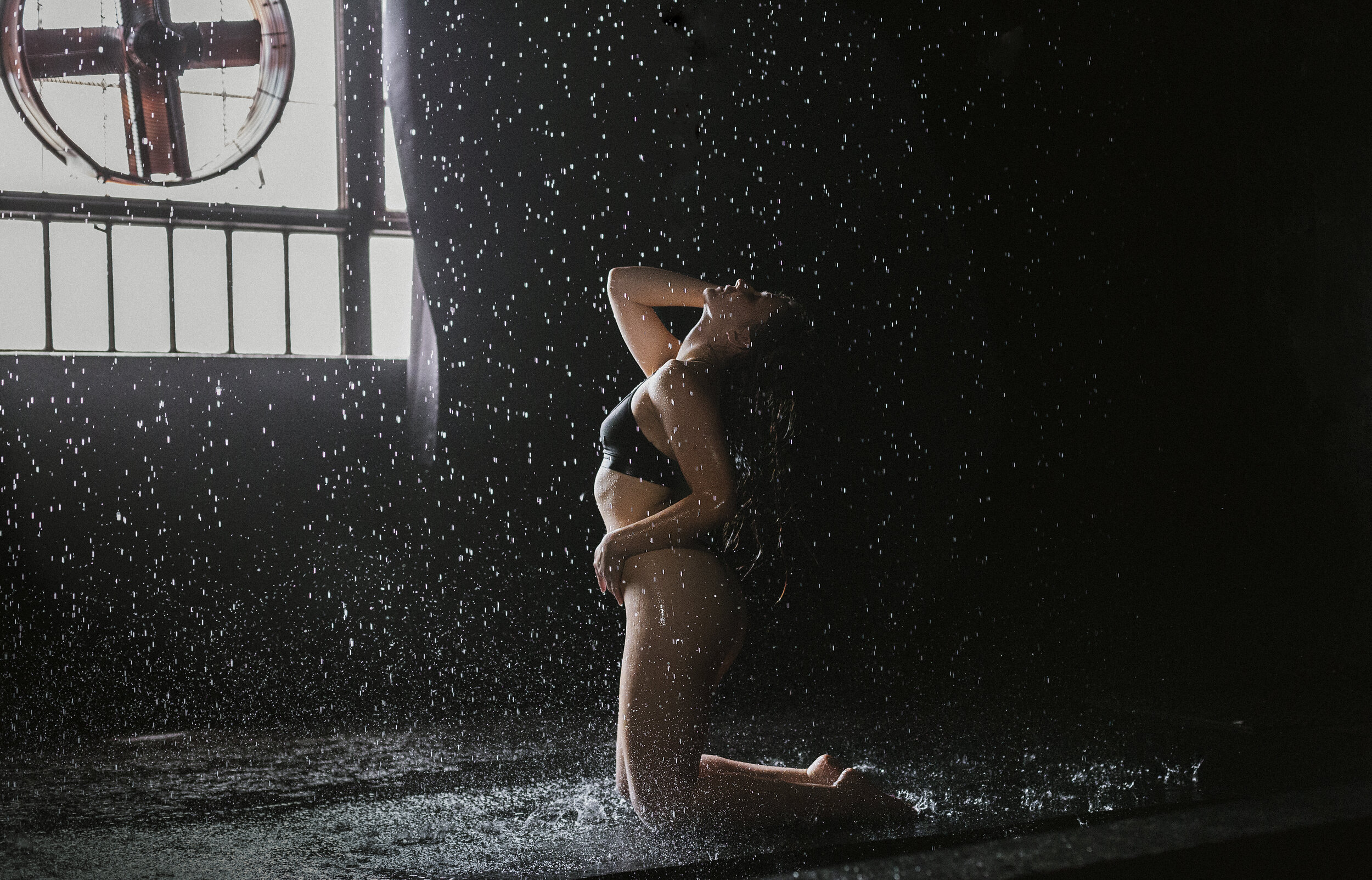 Southern California Boudoir Photography Of A Woman Kneeling While Water Is Coming Down On Her Using Natural Light