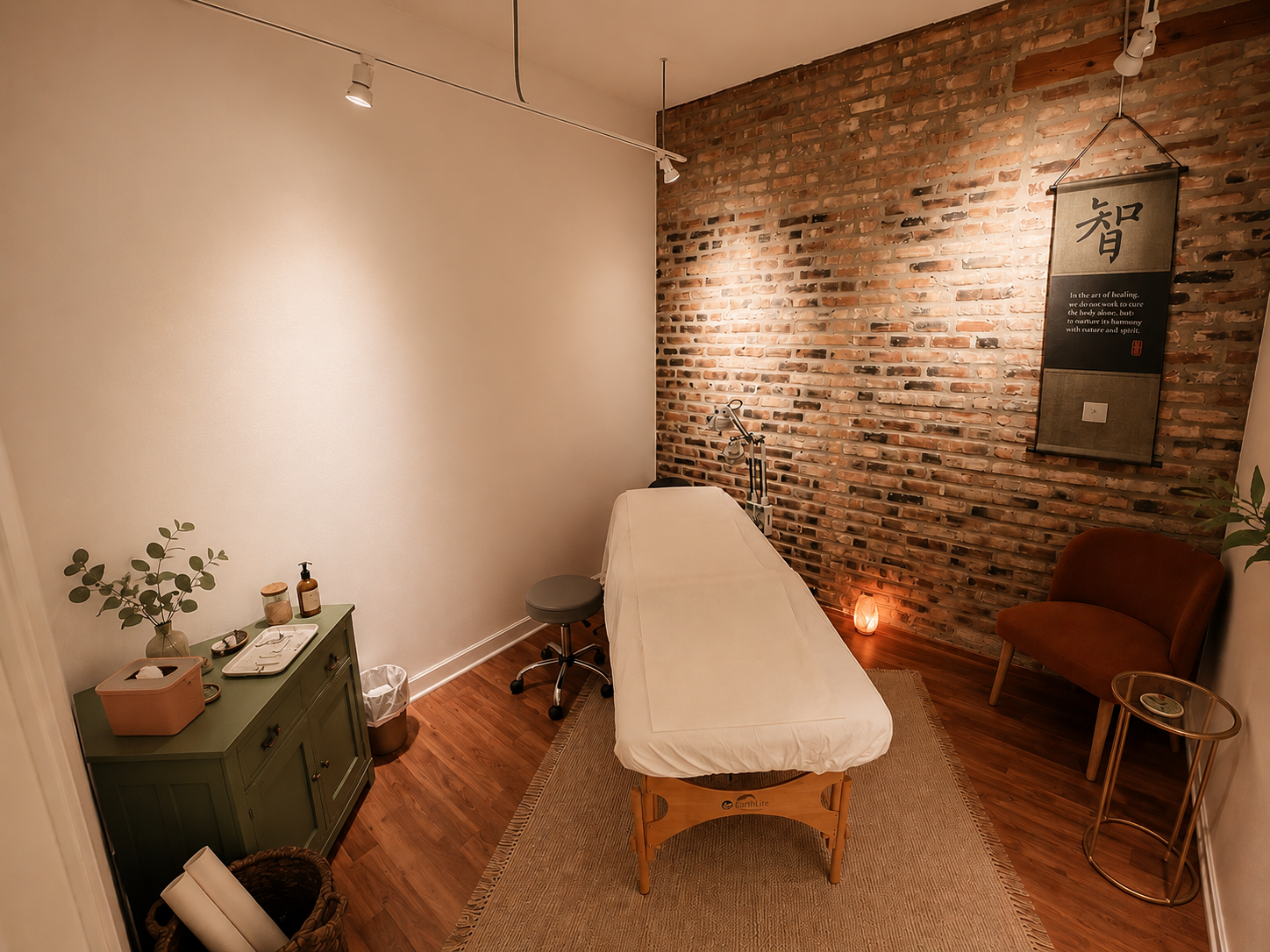 Warm, softly lit acupuncture treatment room with exposed brick walls, a treatment table, natural textures, and calming earthy decor in a minimalist Chicago wellness clinic.