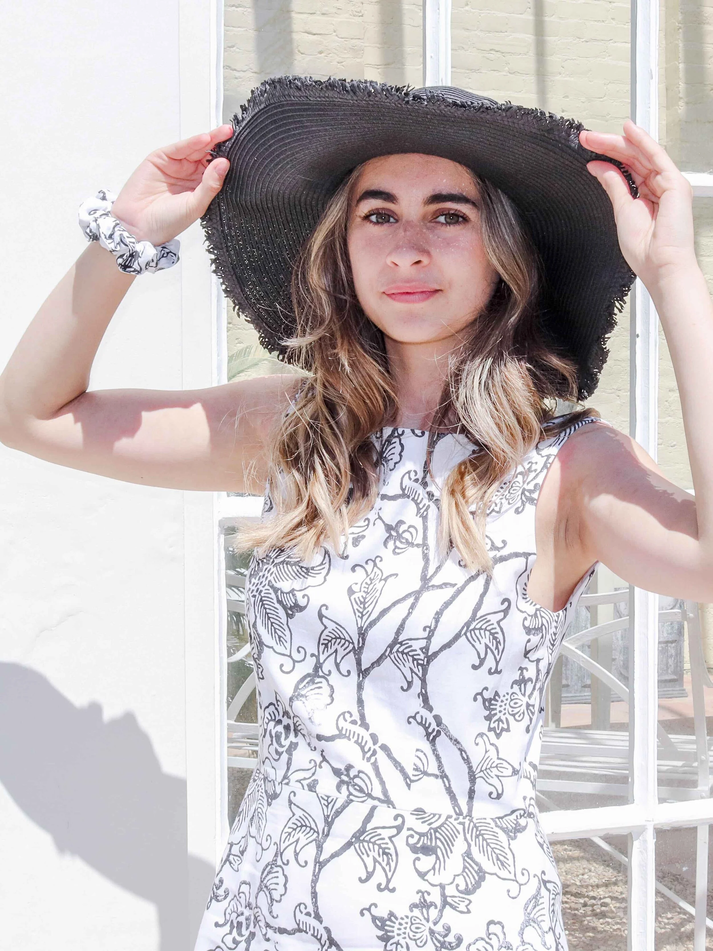 Slow fashion brands | Black and white floral printed shift dress with large black hat for the races
