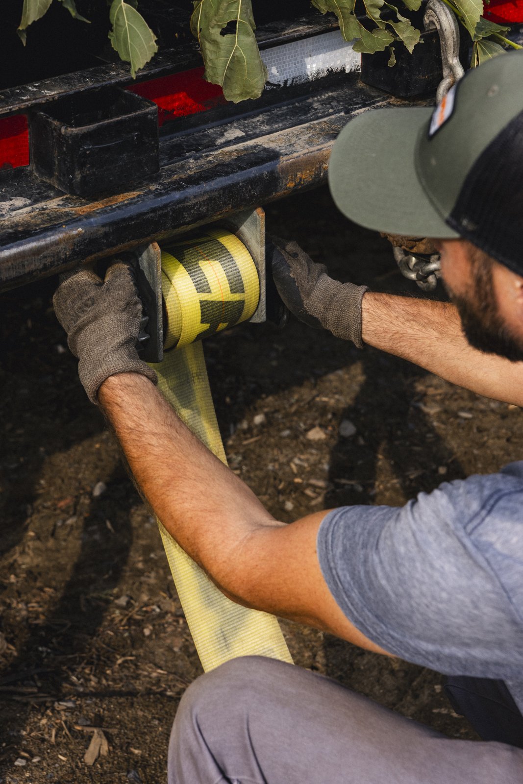 Homme attachant une sangle jaune sur une remorque