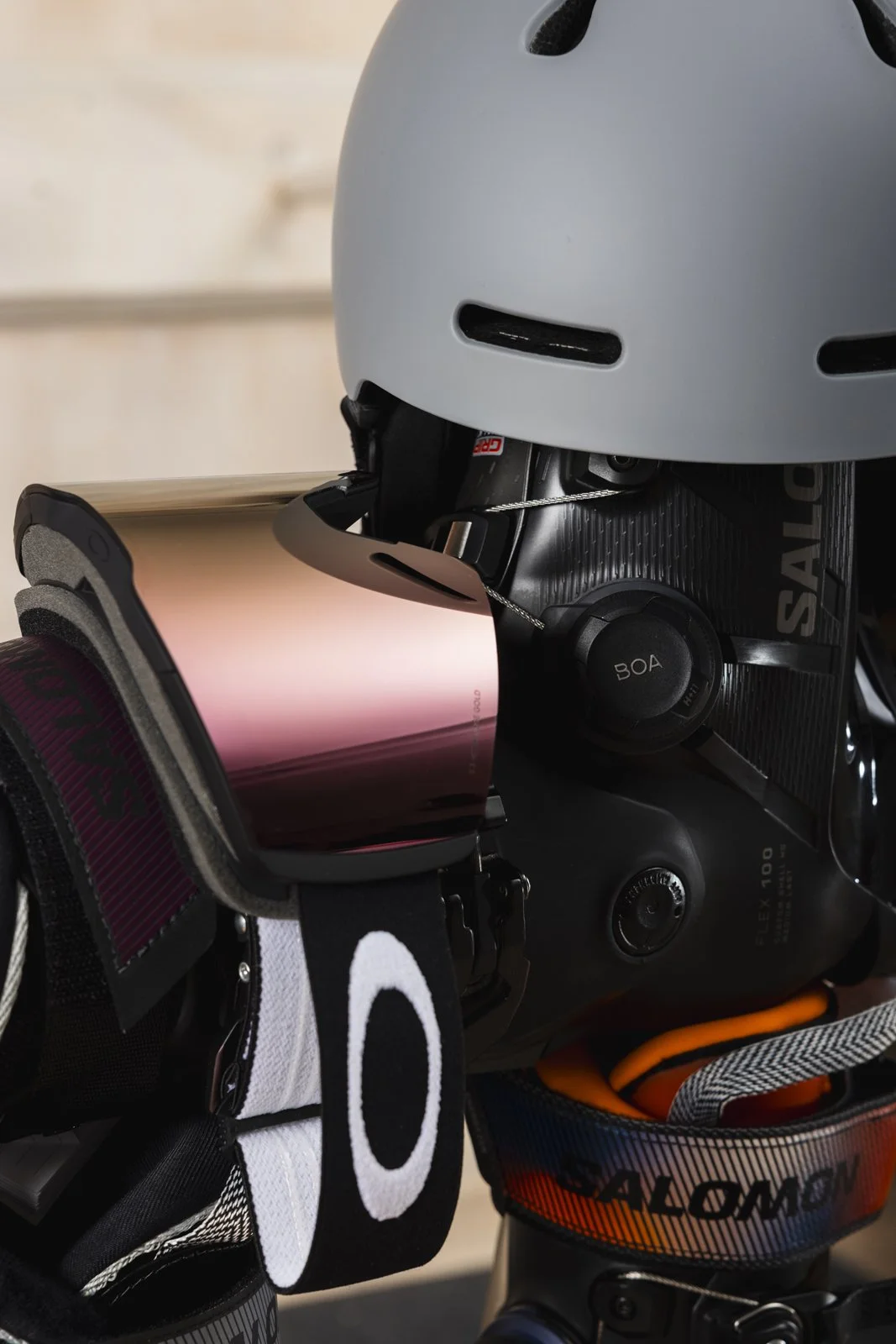 Casque de vélo gris, lunettes de soleil roses réfléchissantes sur un guidon de vélo noir avec systèmes de fixation et élastiques, divers accessoires de vélo colorés colorés attachés autour.