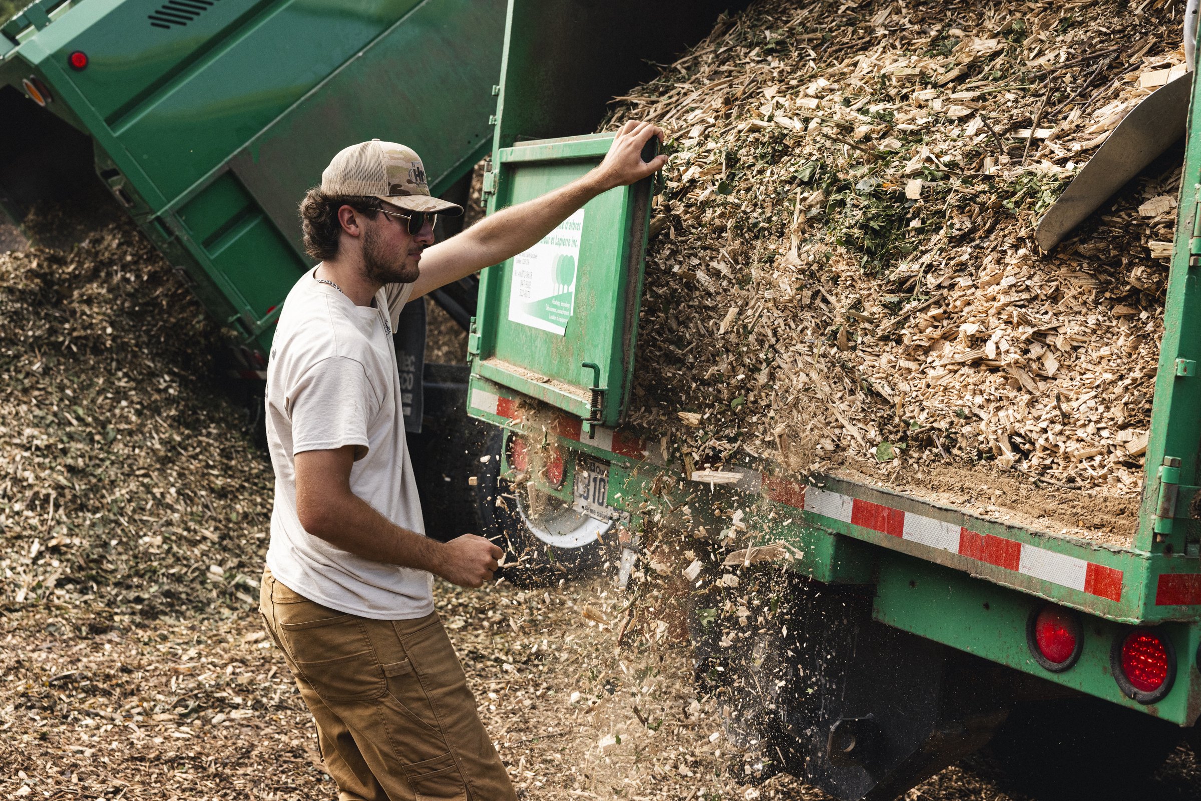 Un homme déversant des copeaux de bois d'un camion de livraison.