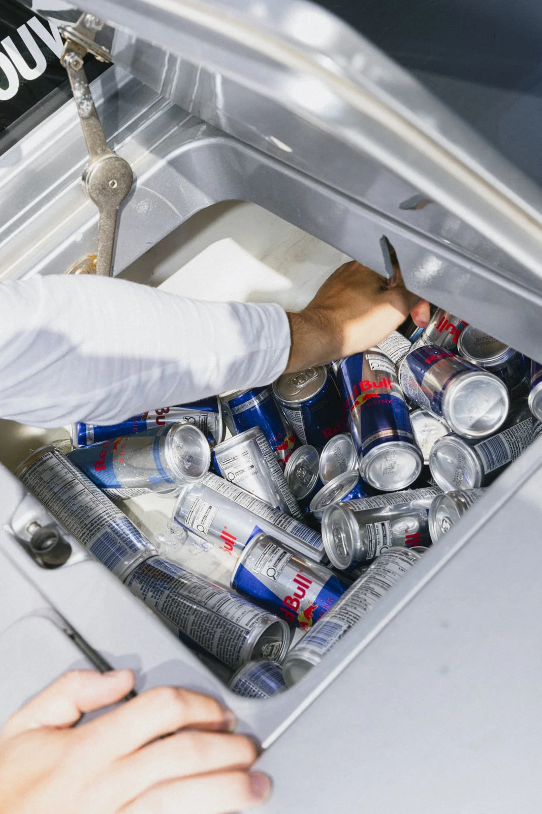 Une personne met des canettes de Red Bull dans un congélateur.