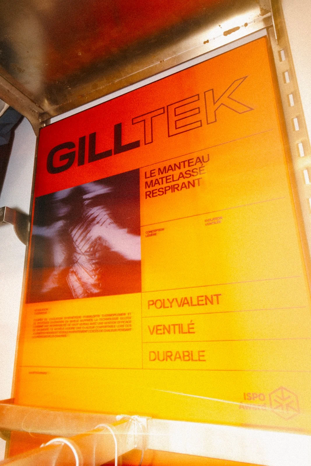 Une affiche orange et rouge pour le matelas Gilltek, décrivant ses caractéristiques comme léger, respirant, polyvalent, ventilé et durable.