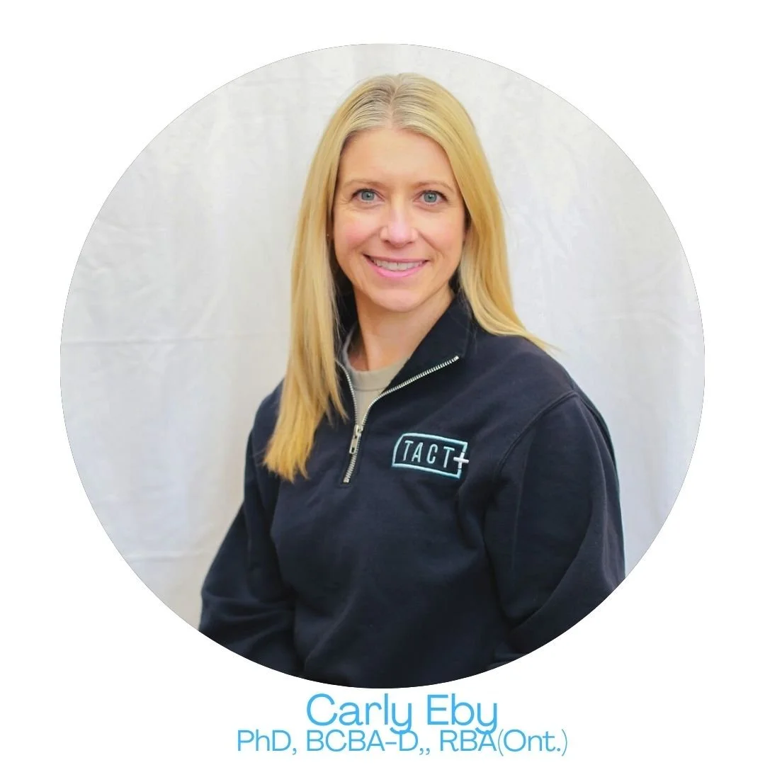 Portrait of Carly Eby wearing a black jacket with a logo, standing against a light background. Text below identifies her as a PhD with various credentials.