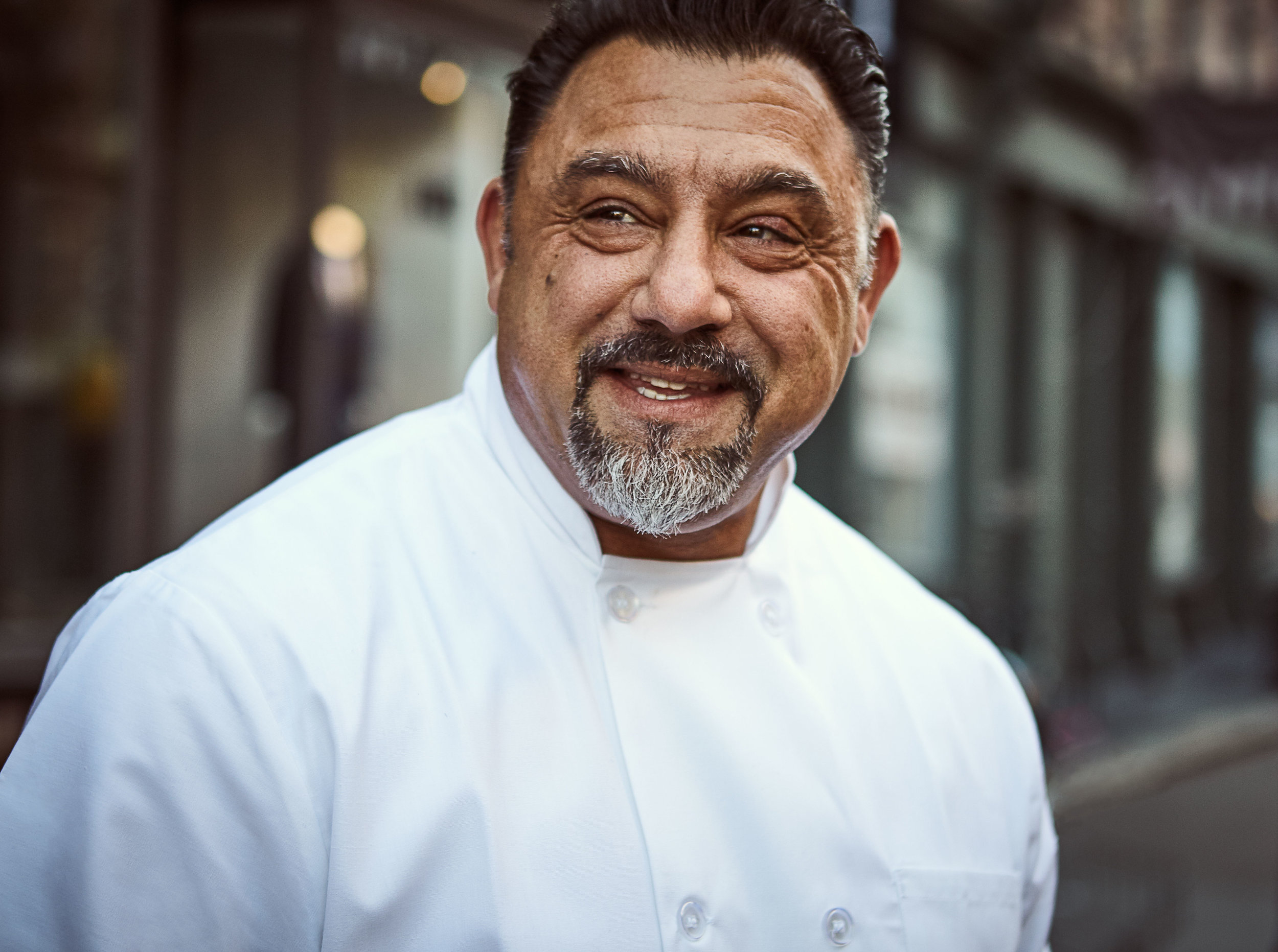 Chef smiling in a white uniform outdoors