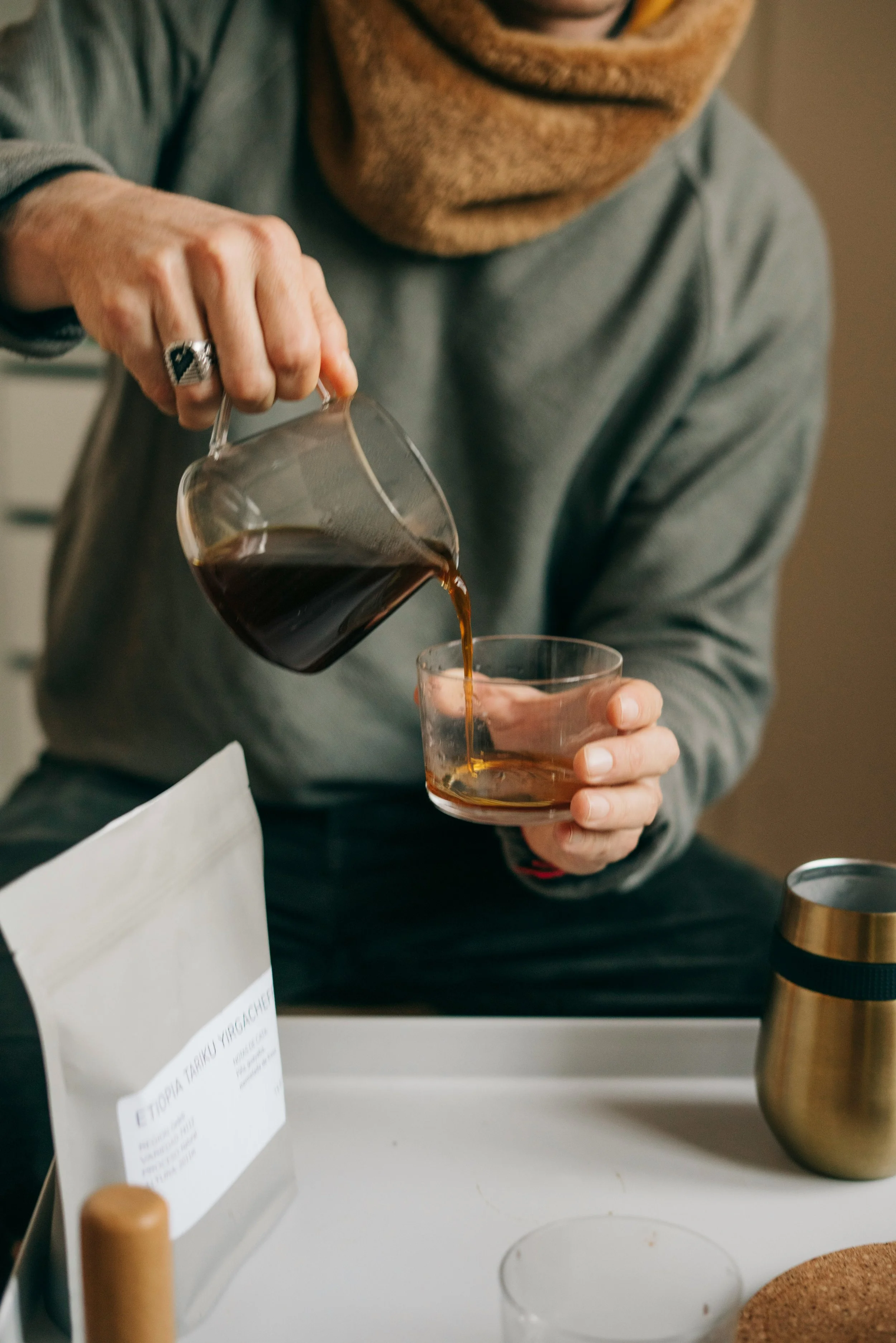 Person pouring coffee into glass