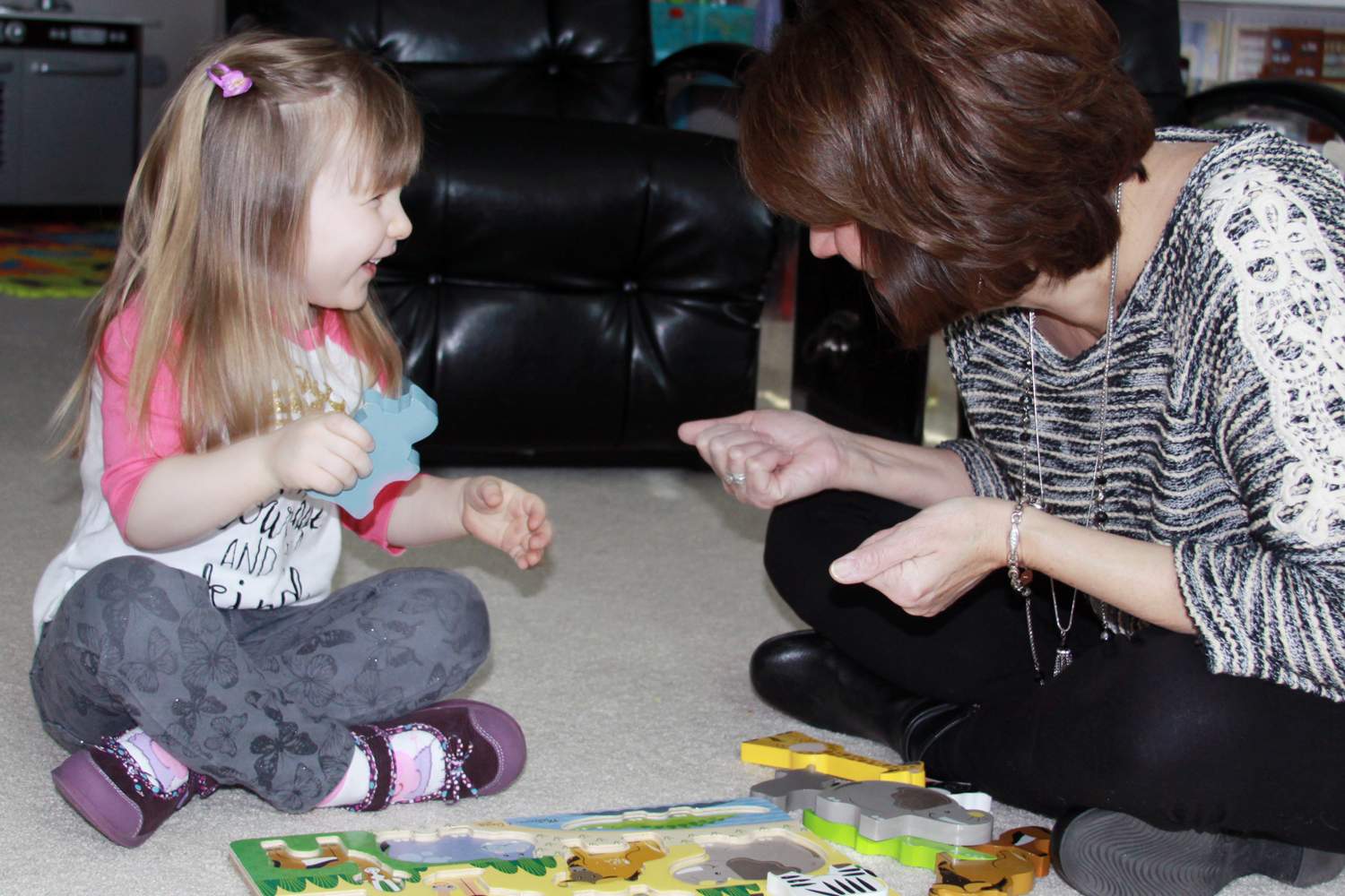 Pediatric speech-language pathologist providing in-home speech therapy to a child