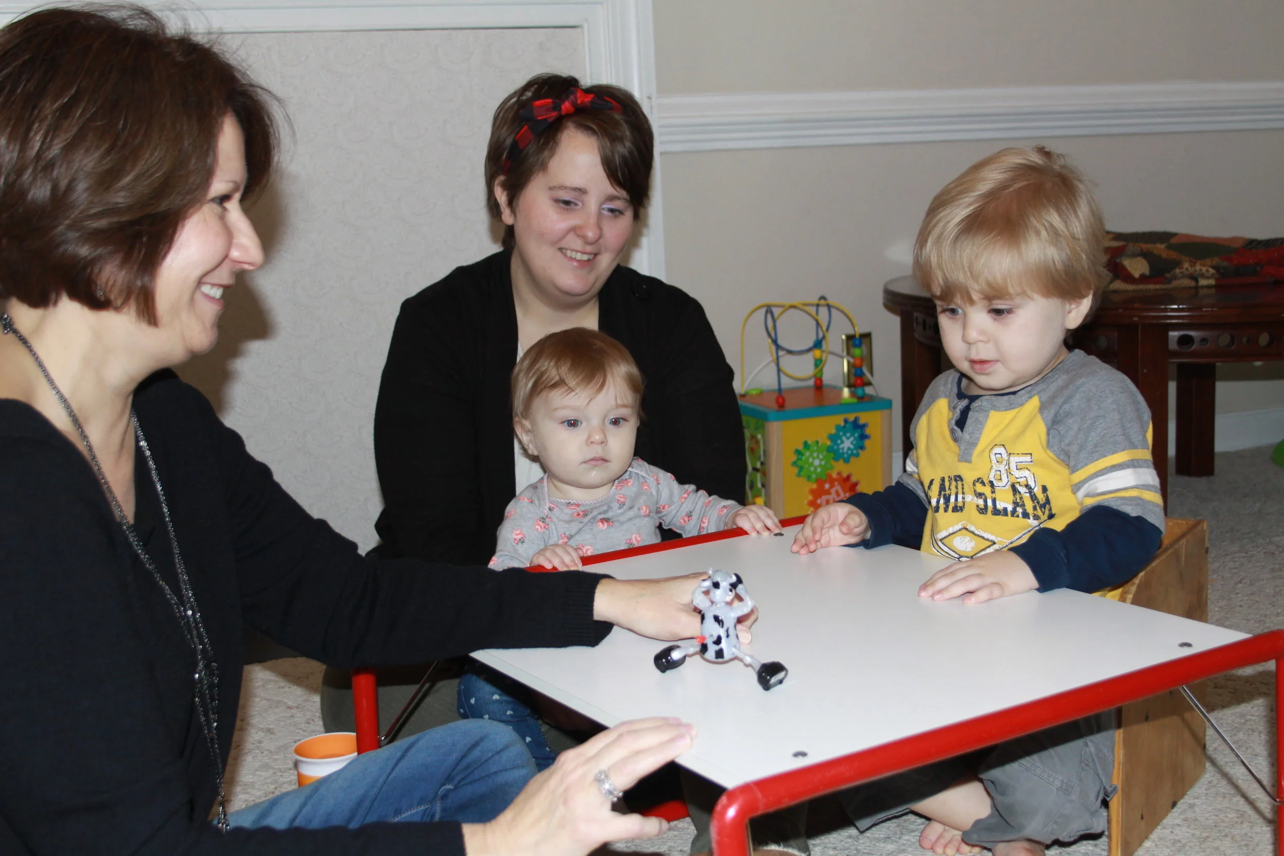 Sherry providing speech therapy to a child while family members participate at the table.