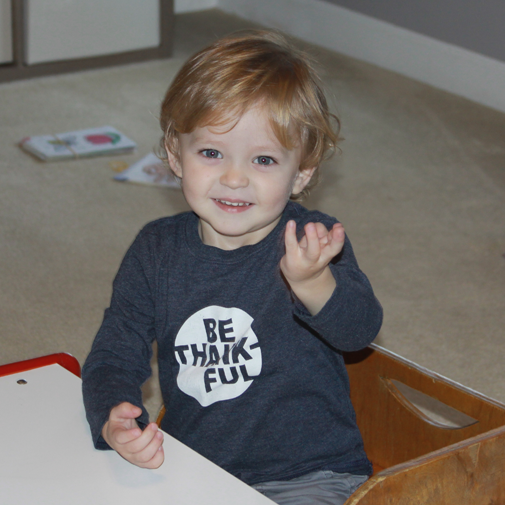 Child smiling during a pediatric speech therapy session.
