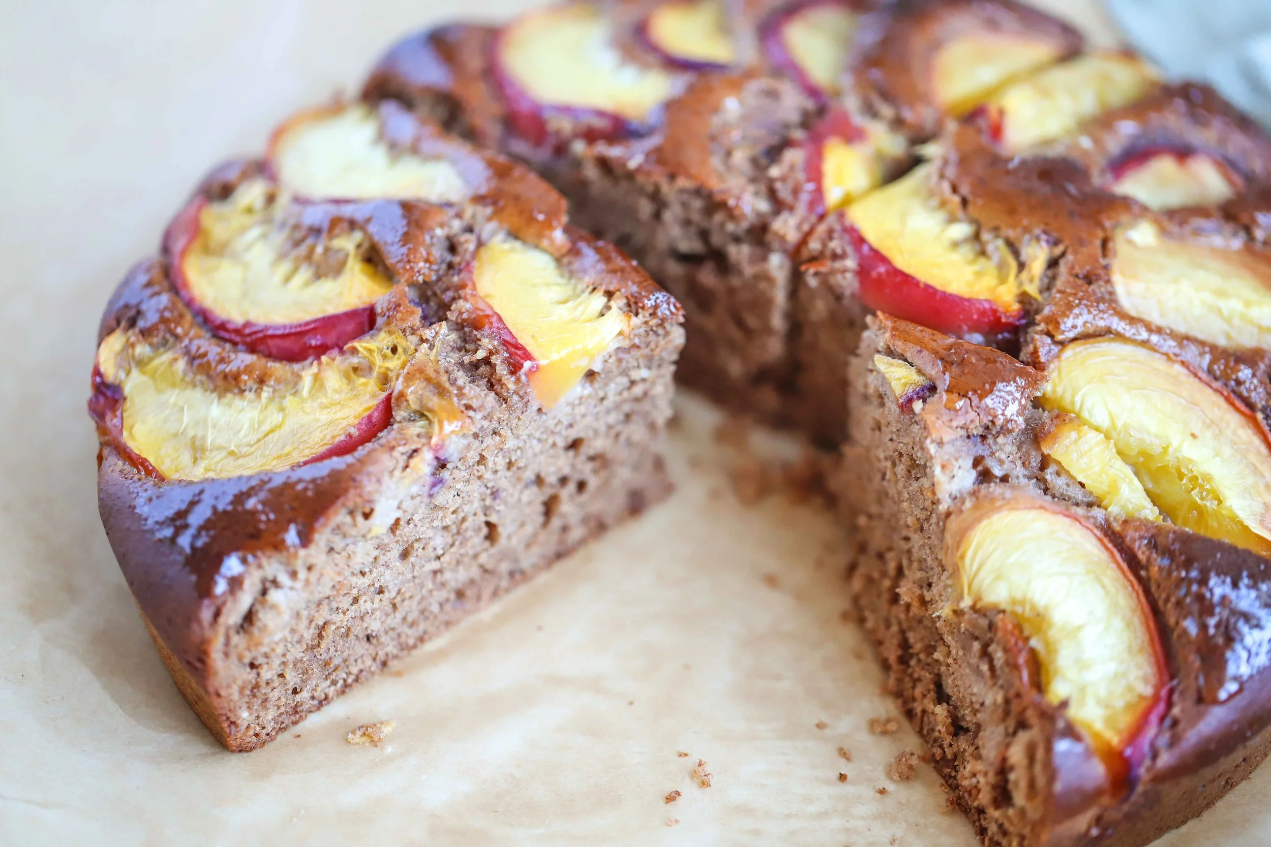 Sliced Peach Almond Cake on a piece of parchment paper