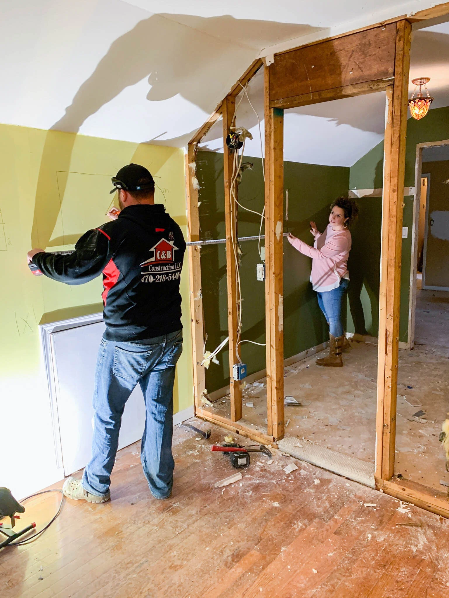 Contractor measuring and planning wall changes during a residential home renovation project in the Lake Allatoona area.