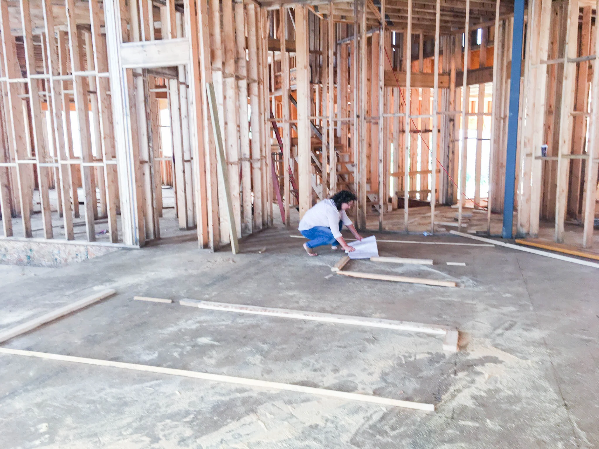 Betsy Manley reviewing construction plans on-site during the framing phase of a Lake Allatoona home renovation.