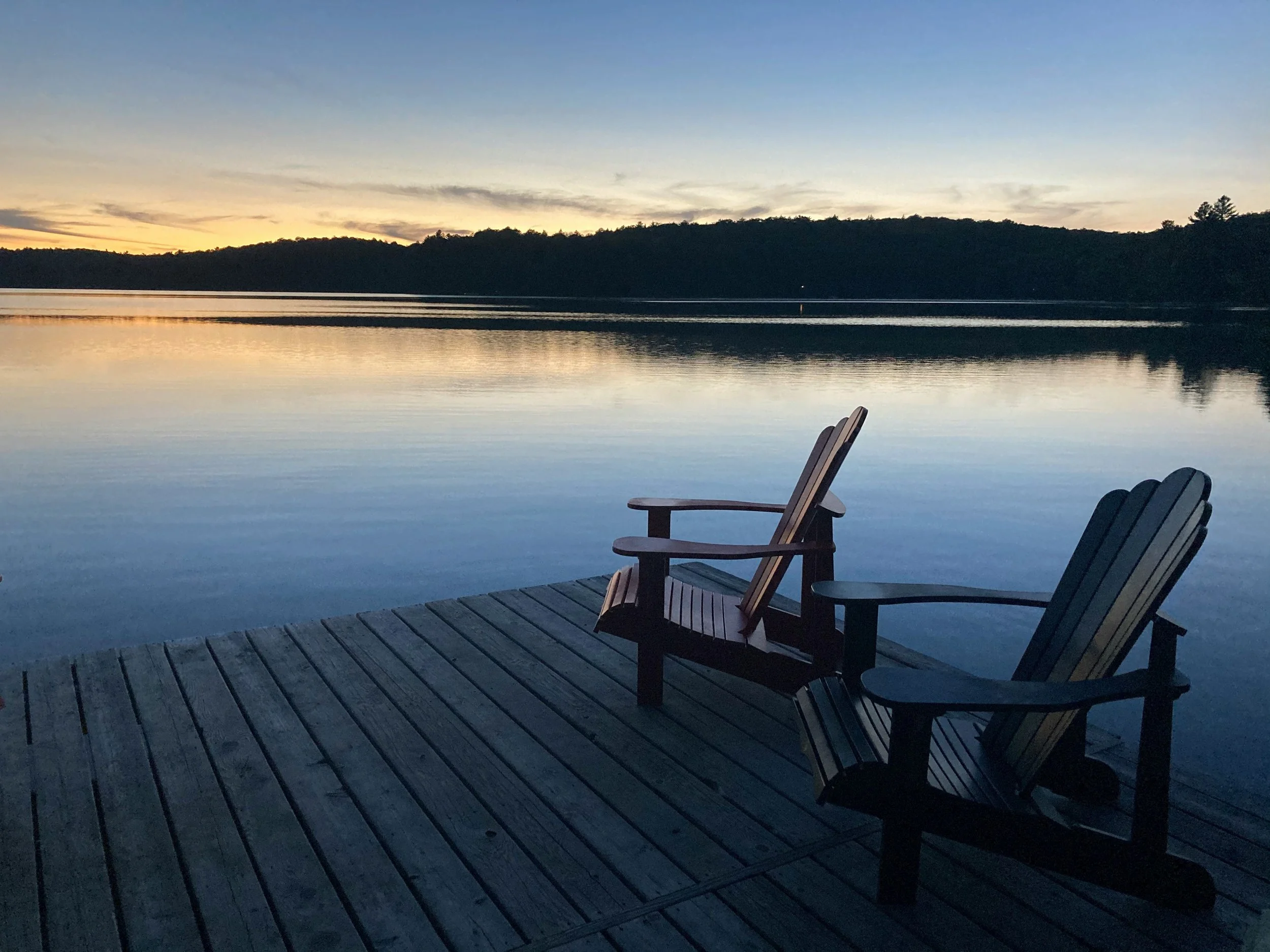 Peaceful Lake Allatoona waterfront at sunset with Adirondack chairs overlooking the water from a private dock.