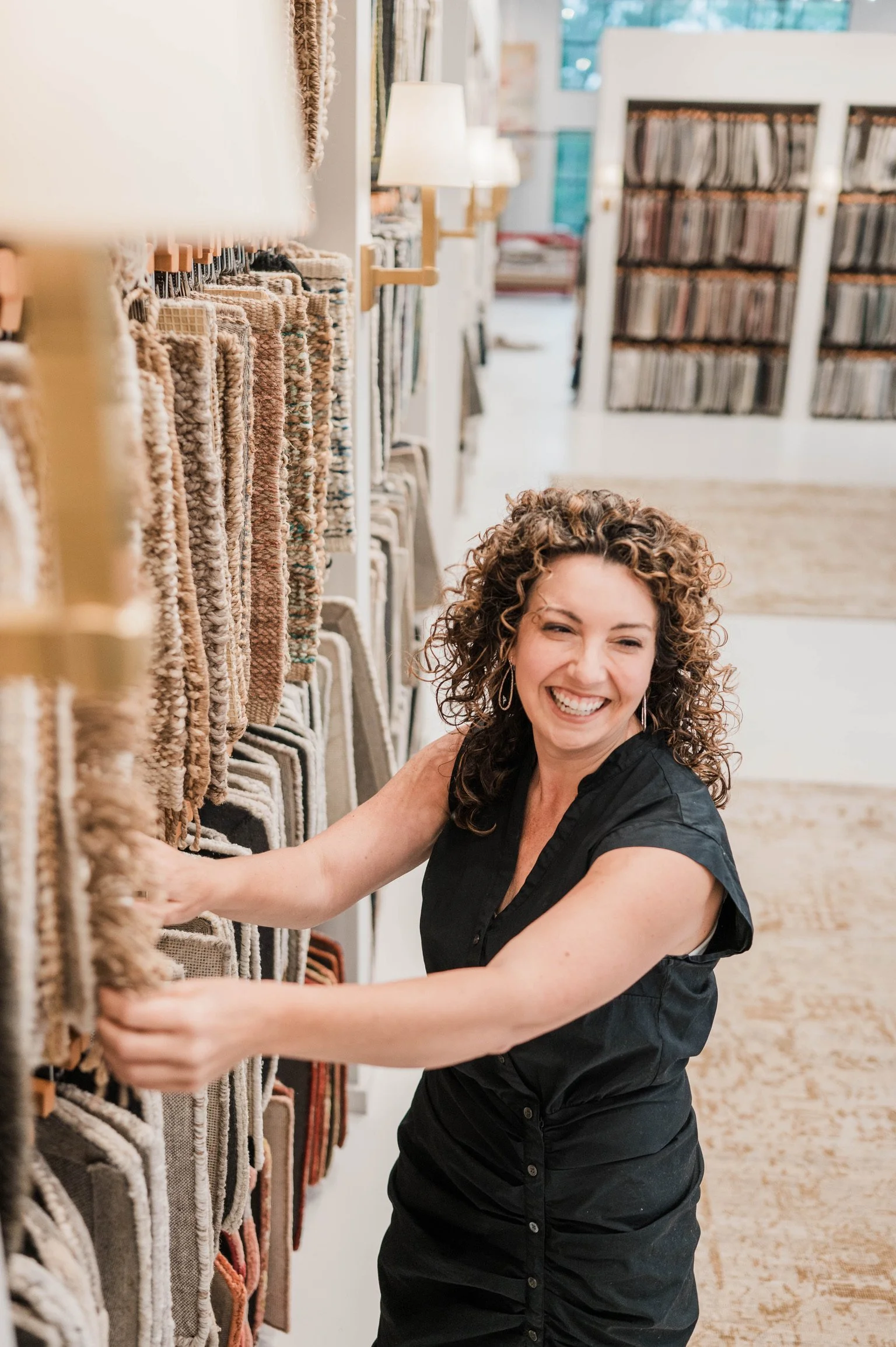 Betsy Manley, Lake Allatoona interior designer and home renovator, selecting neutral rug and textile samples for a design project.