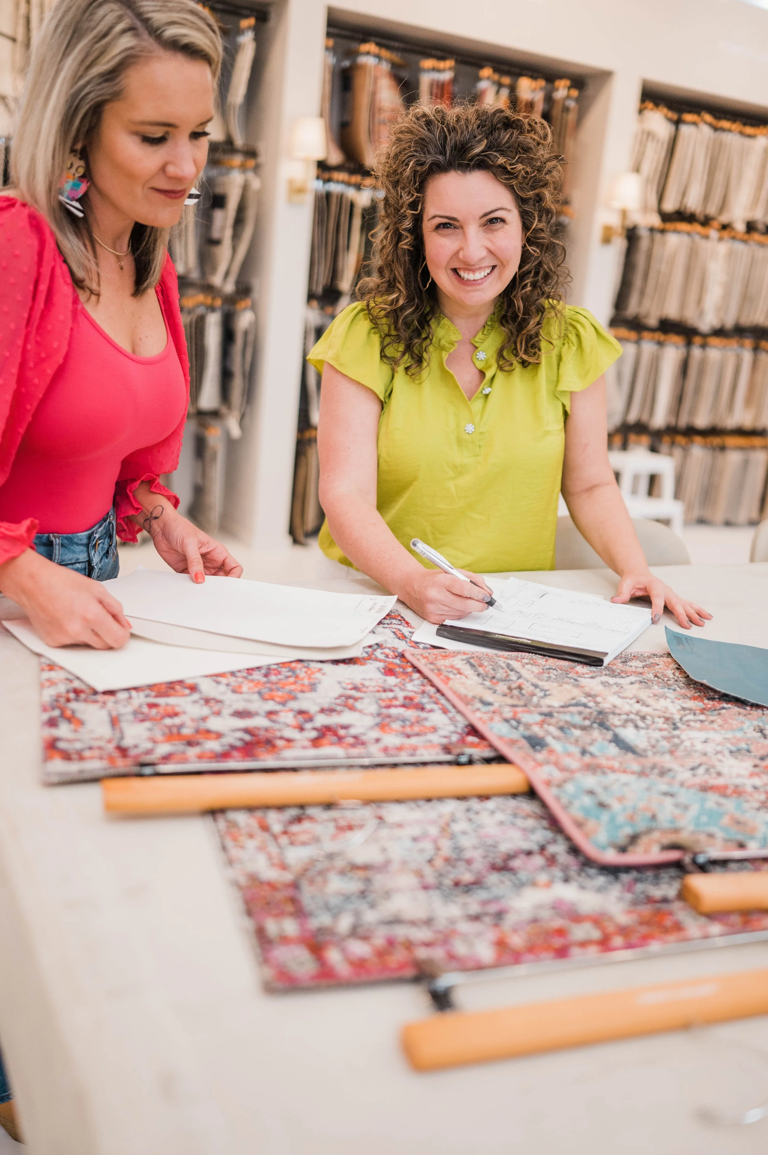 Betsy Manley and her design team reviewing floor plans, rug samples, and materials for a luxury home renovation and interior design project.