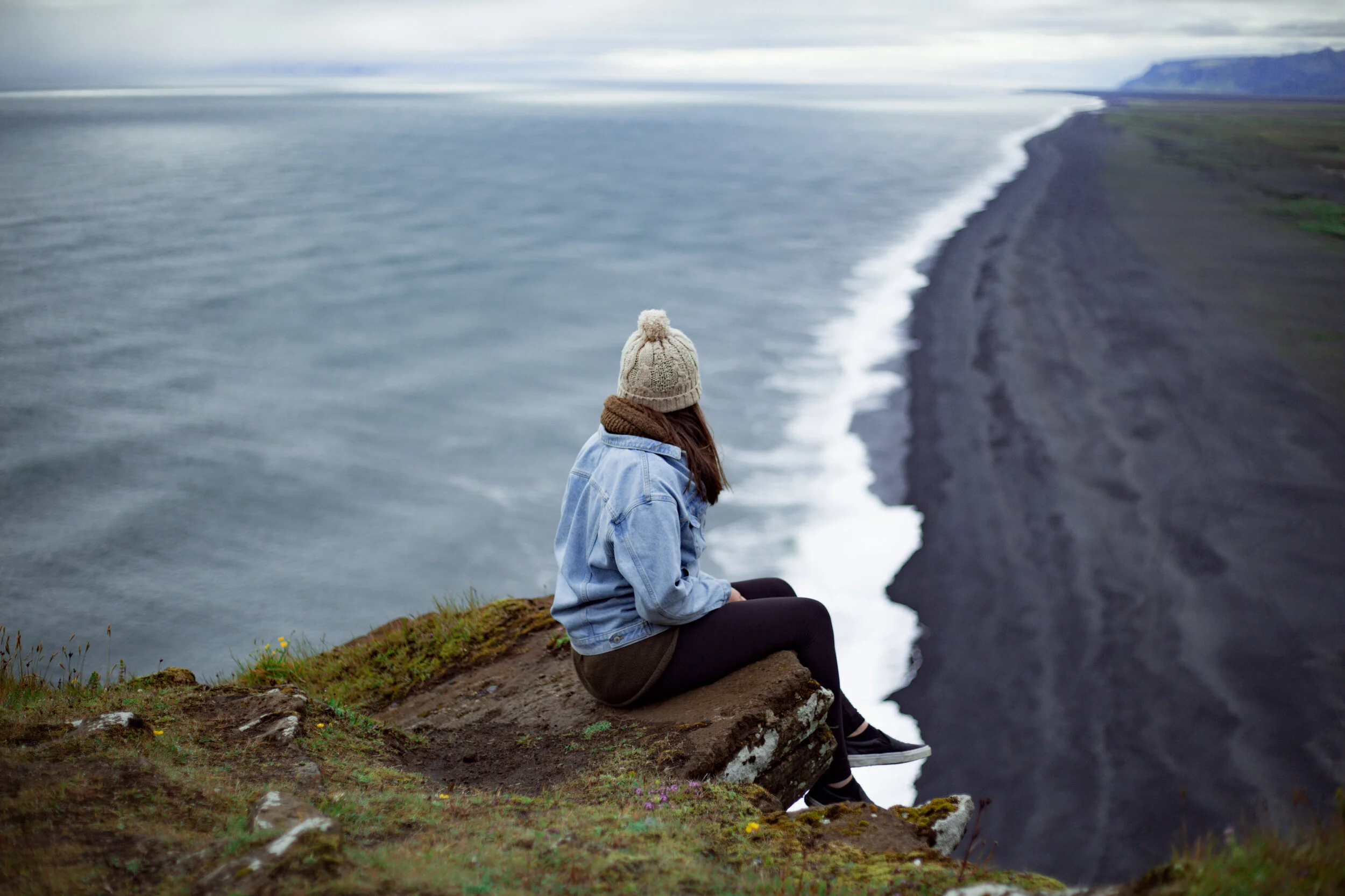 WOMAN SITTING ON CLIFF ICELAND.jpg