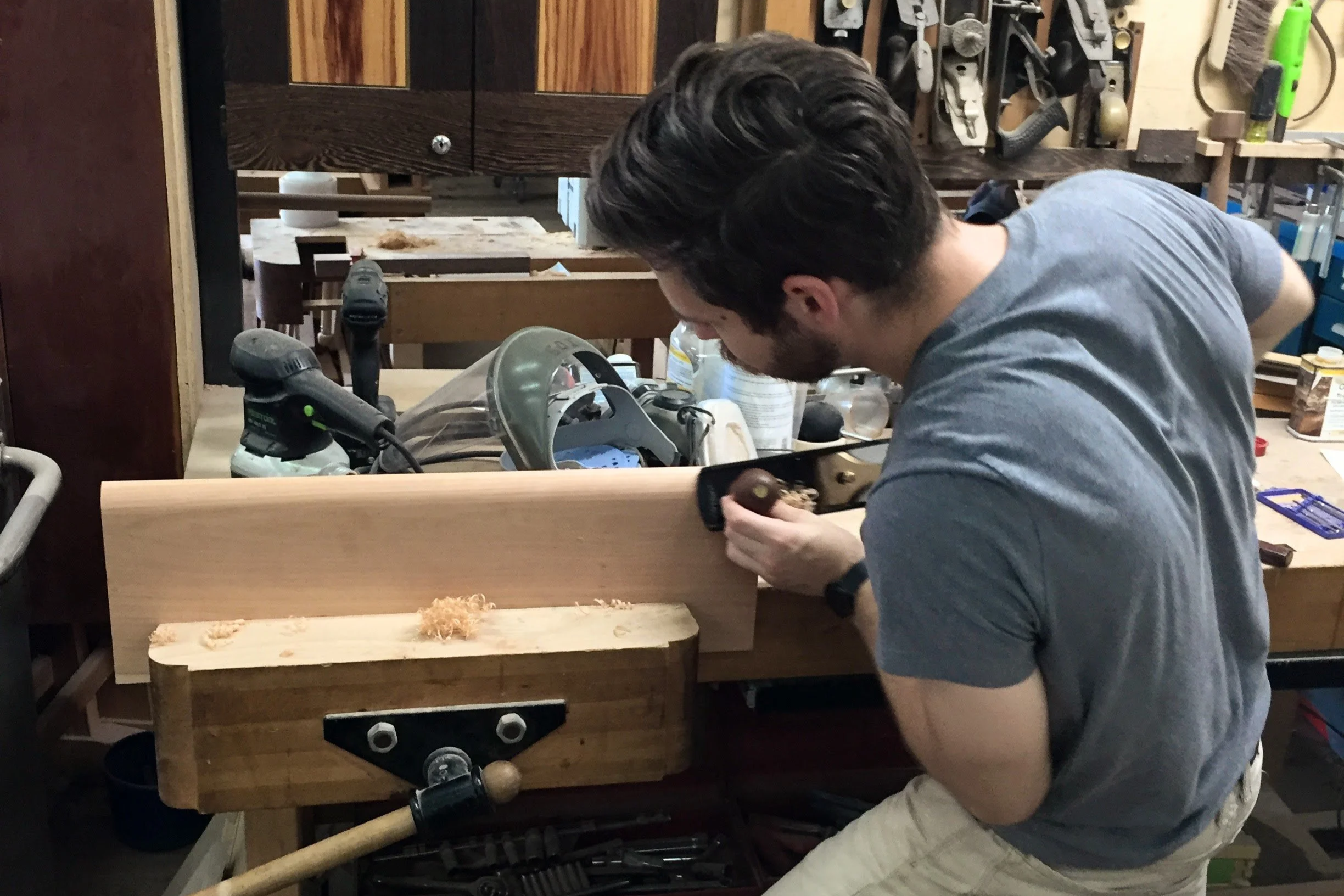 Alexander Lohn hand planing the seat of a meditation bench.