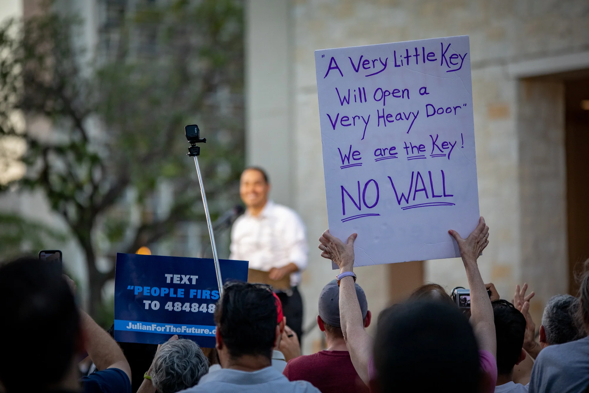 An individual holds an anti-border wall sign at the Castro Rally. (Photo by: Joel Pena , Photographer - The San Antonio Sentinel)