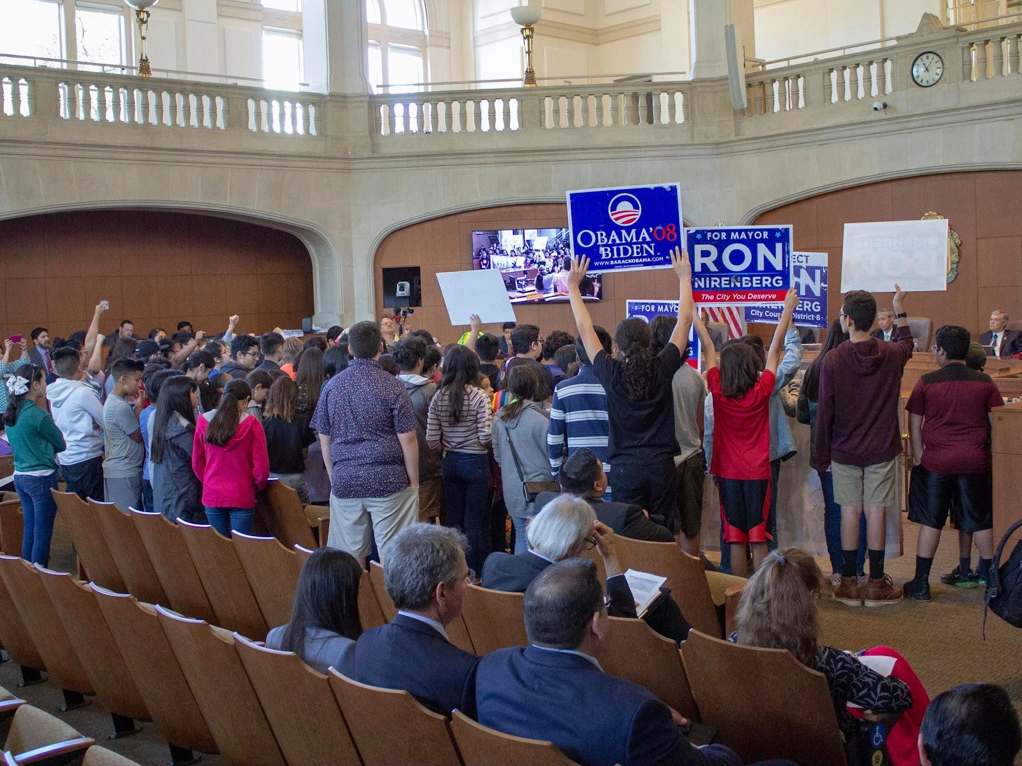 Protesters hold repurposed Nirenberg and Obama campaign signs with anti-gentrification slogans emblazoned on the flip side. (Photo by William Timmerman )