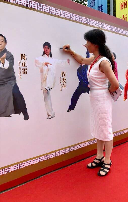 Grandmaster Cheng signing a photo of herself on the Wall of Fame at the 2018 World Tai Chi Cultural Festival in Sanya, China.