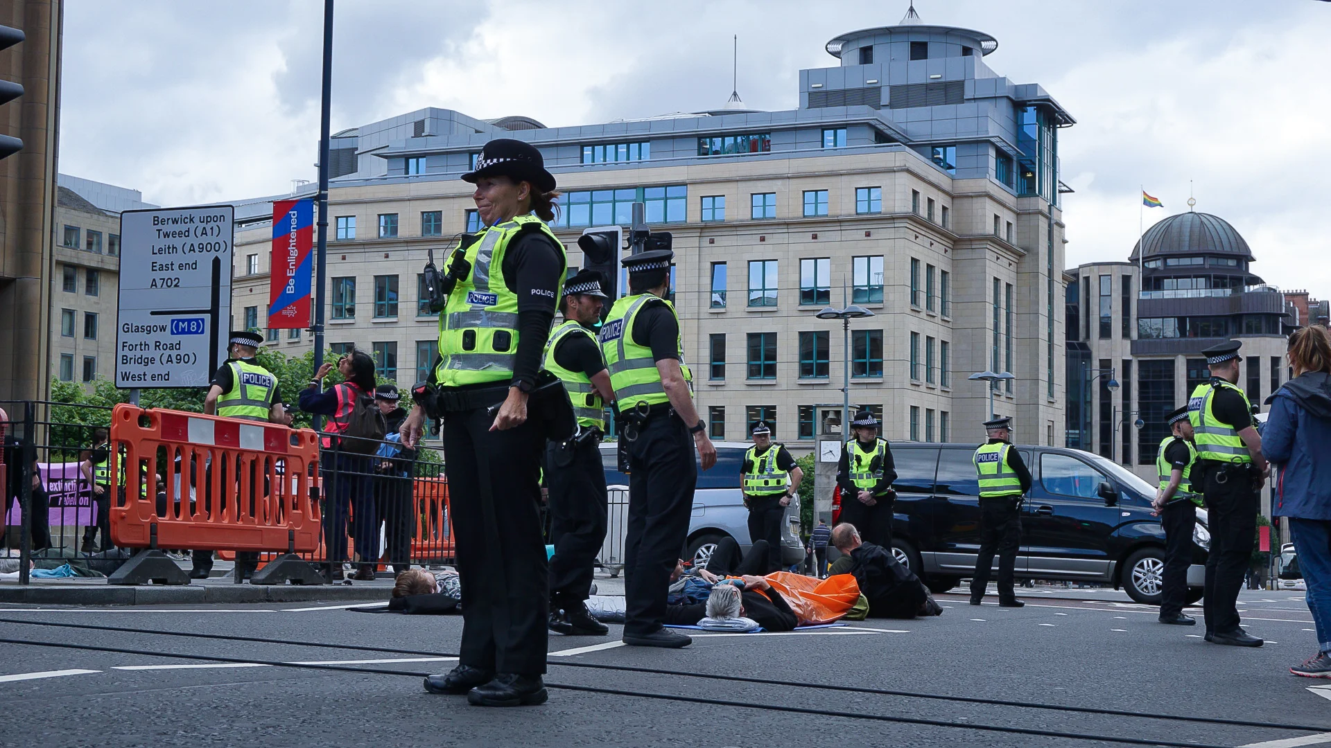 An alarming number of police surround activists who have laid down in the road.