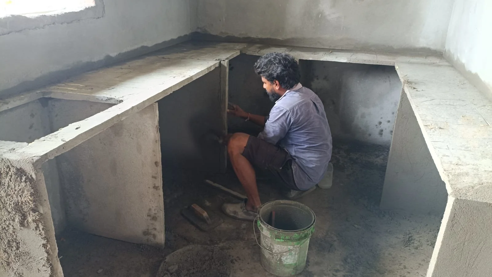 Worker installing plumbing in an apartment.