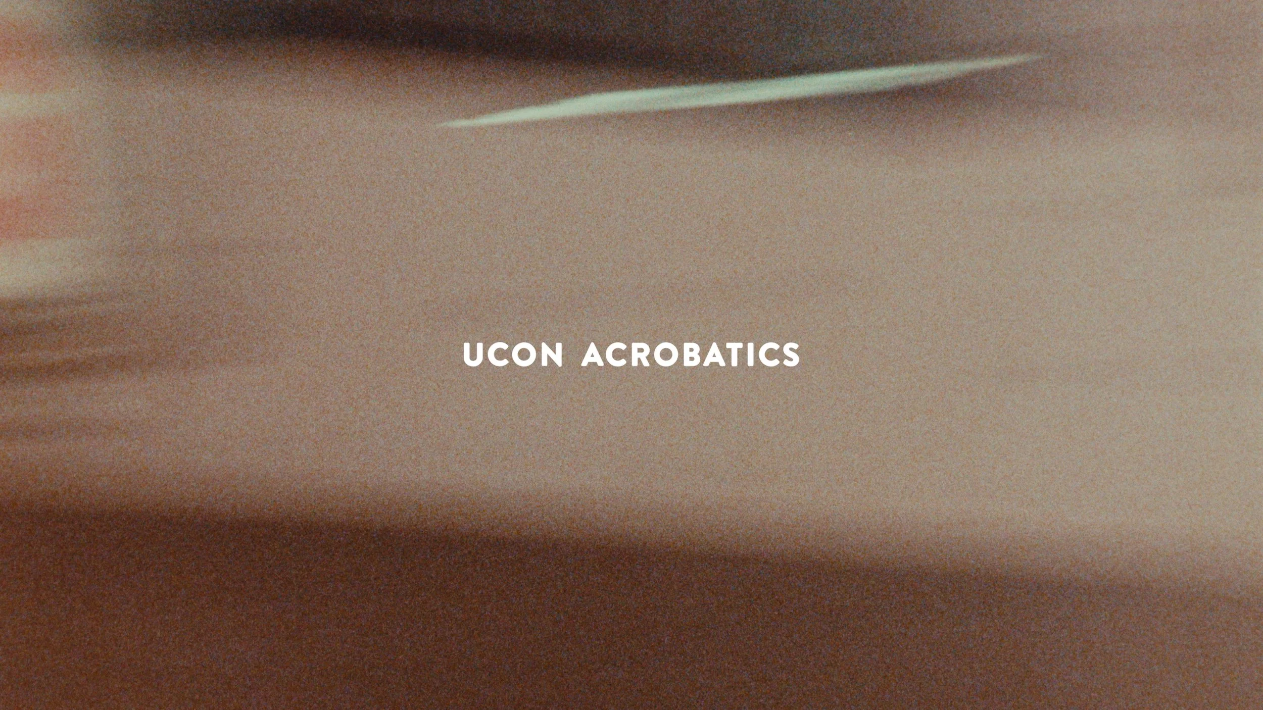 Text overlay on a blurred background reads "UCON ACROBATICS".