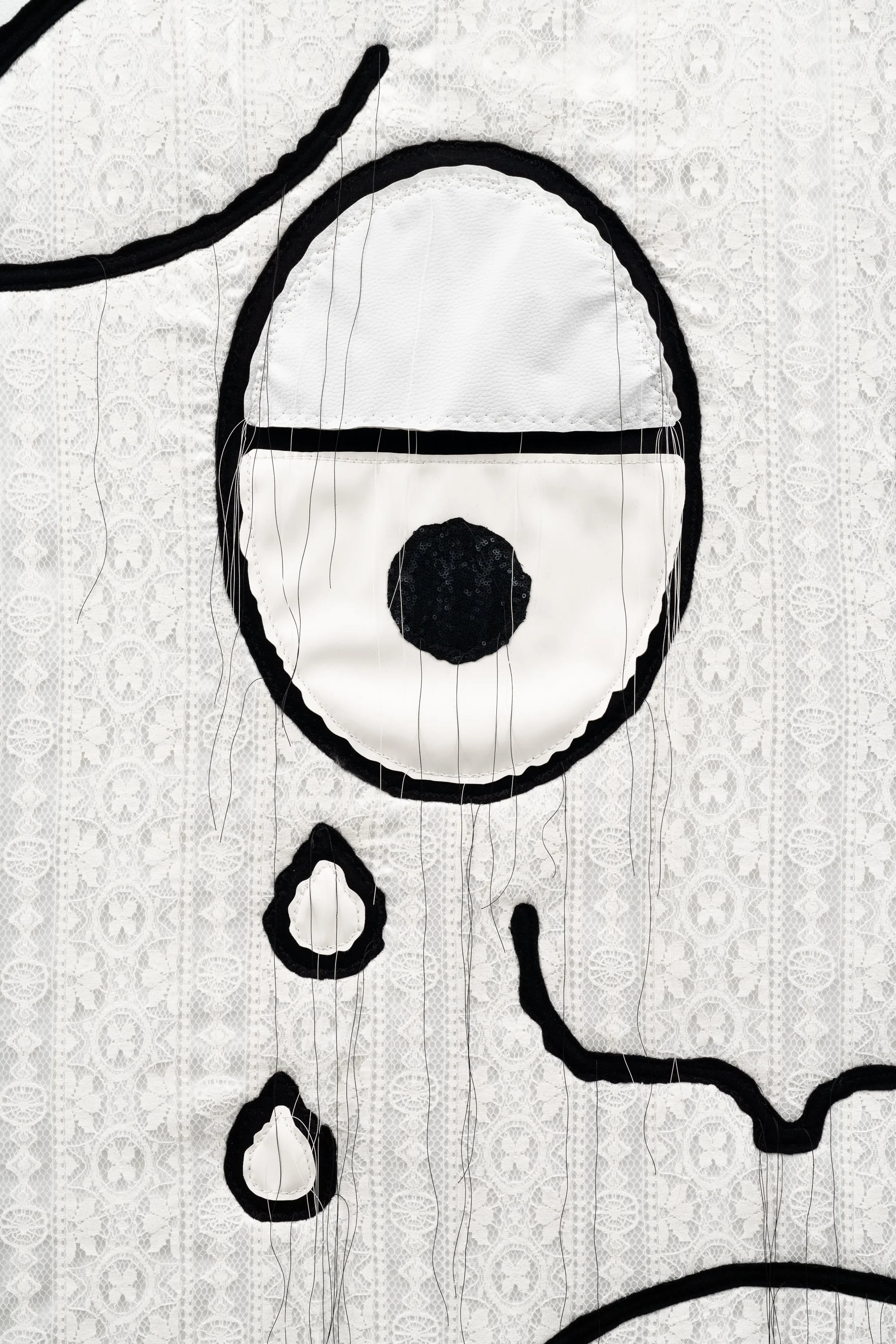 a cartoon crying face made with textile on the wall