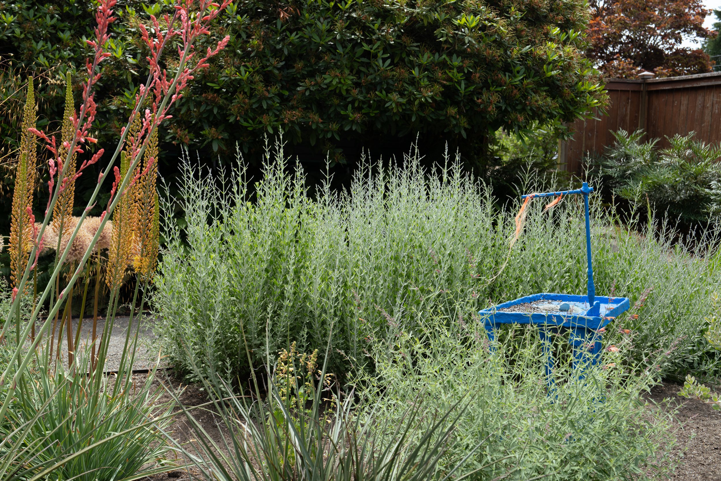 A blue sculpture in a garden.