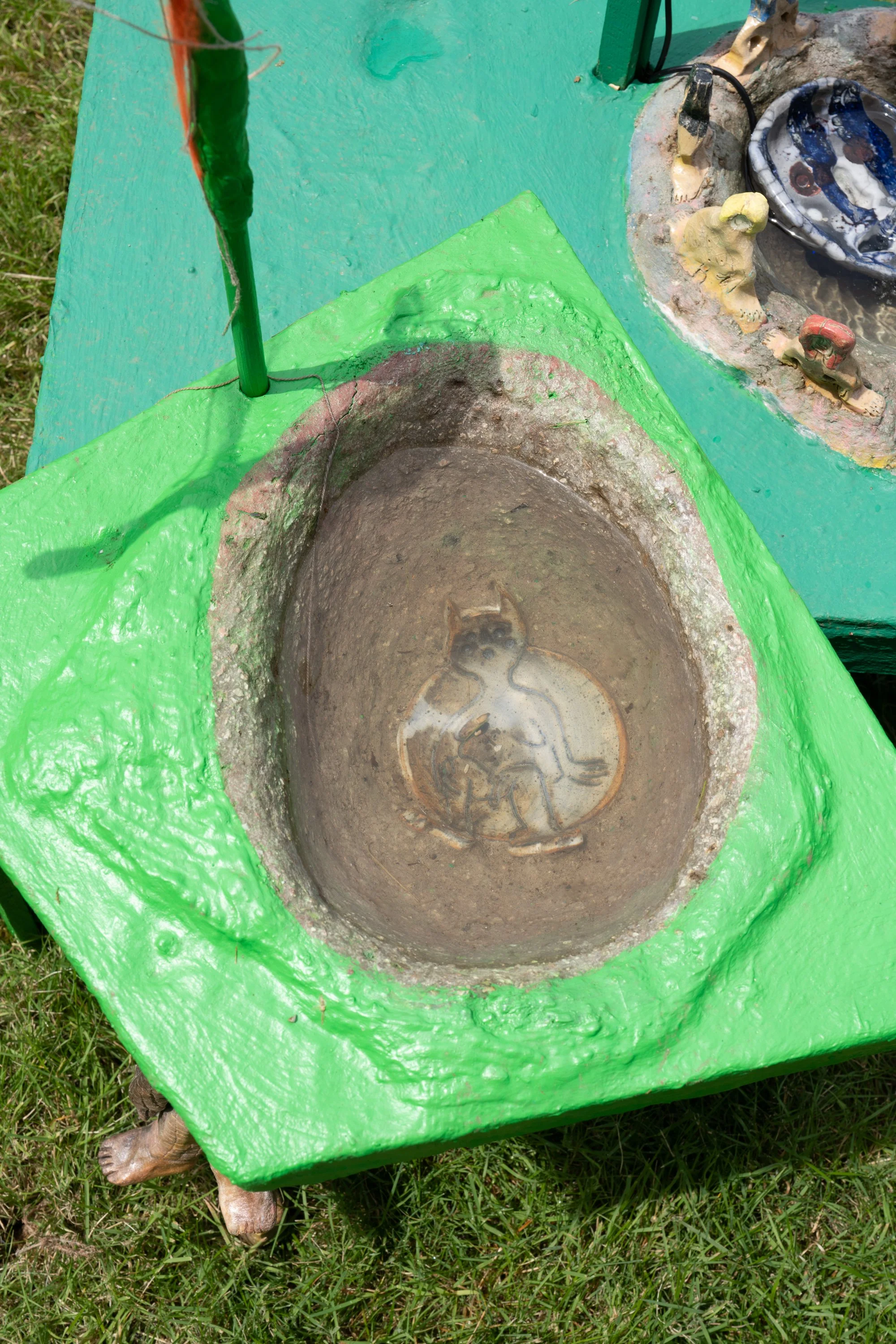 A ceramic figure submerged under water in a basin.