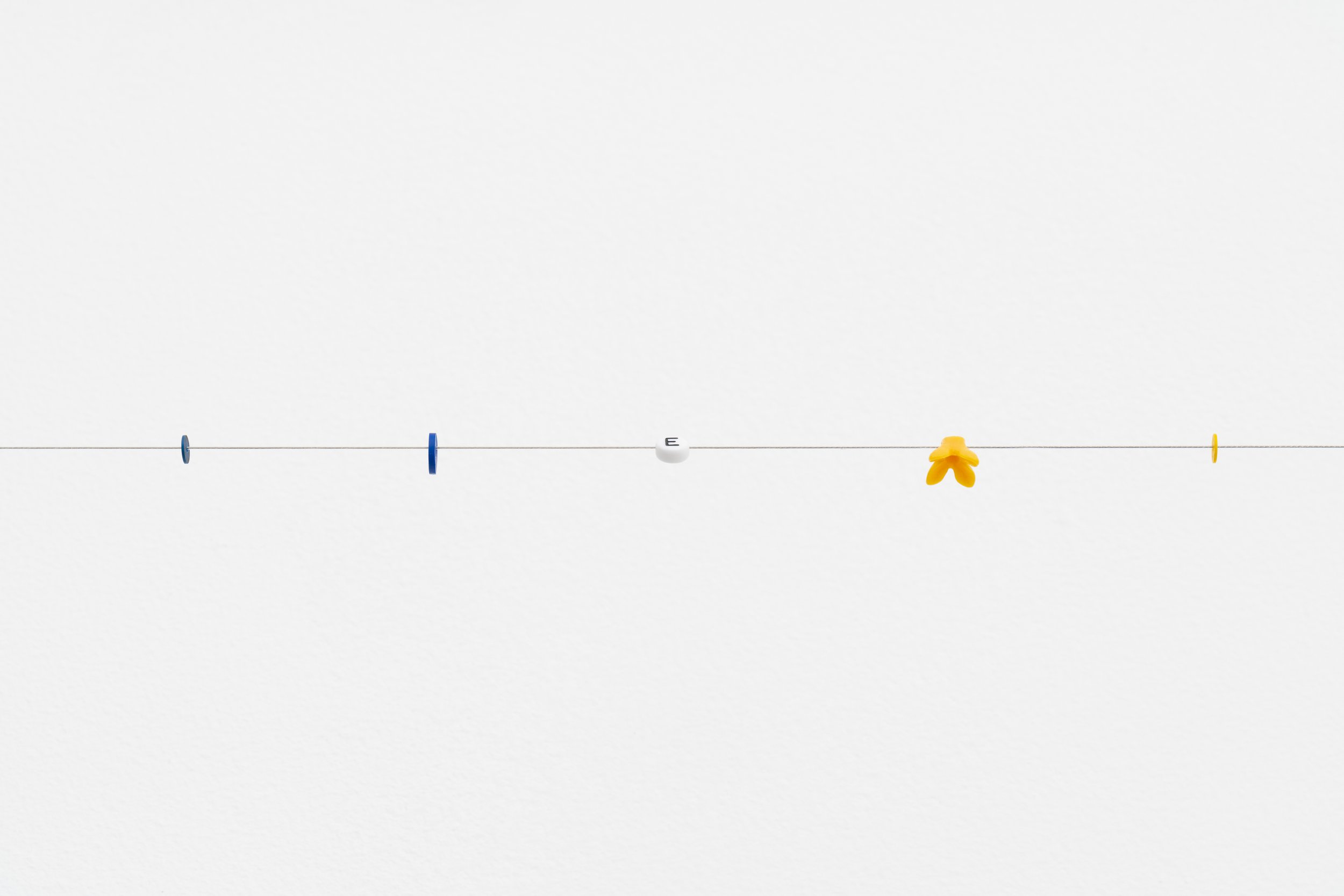small beads on a wire; one of them reads letter E