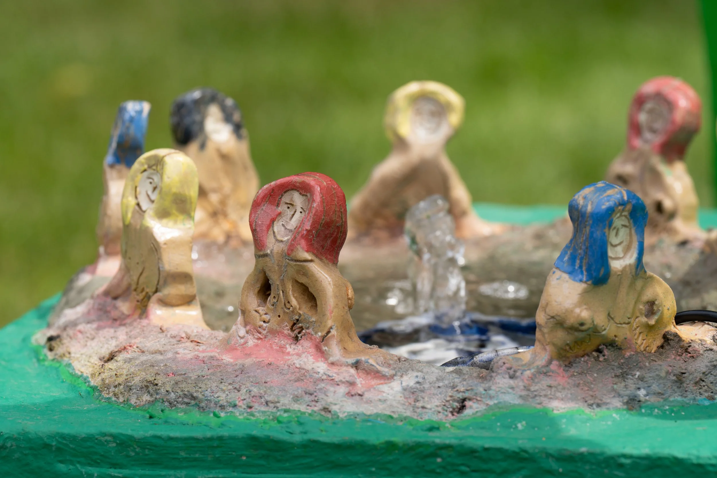 Ceramic figures around a water fountain.